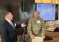 Joint Task Force Civil Support Chief of Staff Col. Christopher Caldwell, right, speaks with Erick Swartz, the senior scientist for the Chemical Biological Incident Response Force, during Defense Strategies Institute’s Joint Civil and DoD CBRN symposium at the National Harbor in Maryland, March 23, 2022.