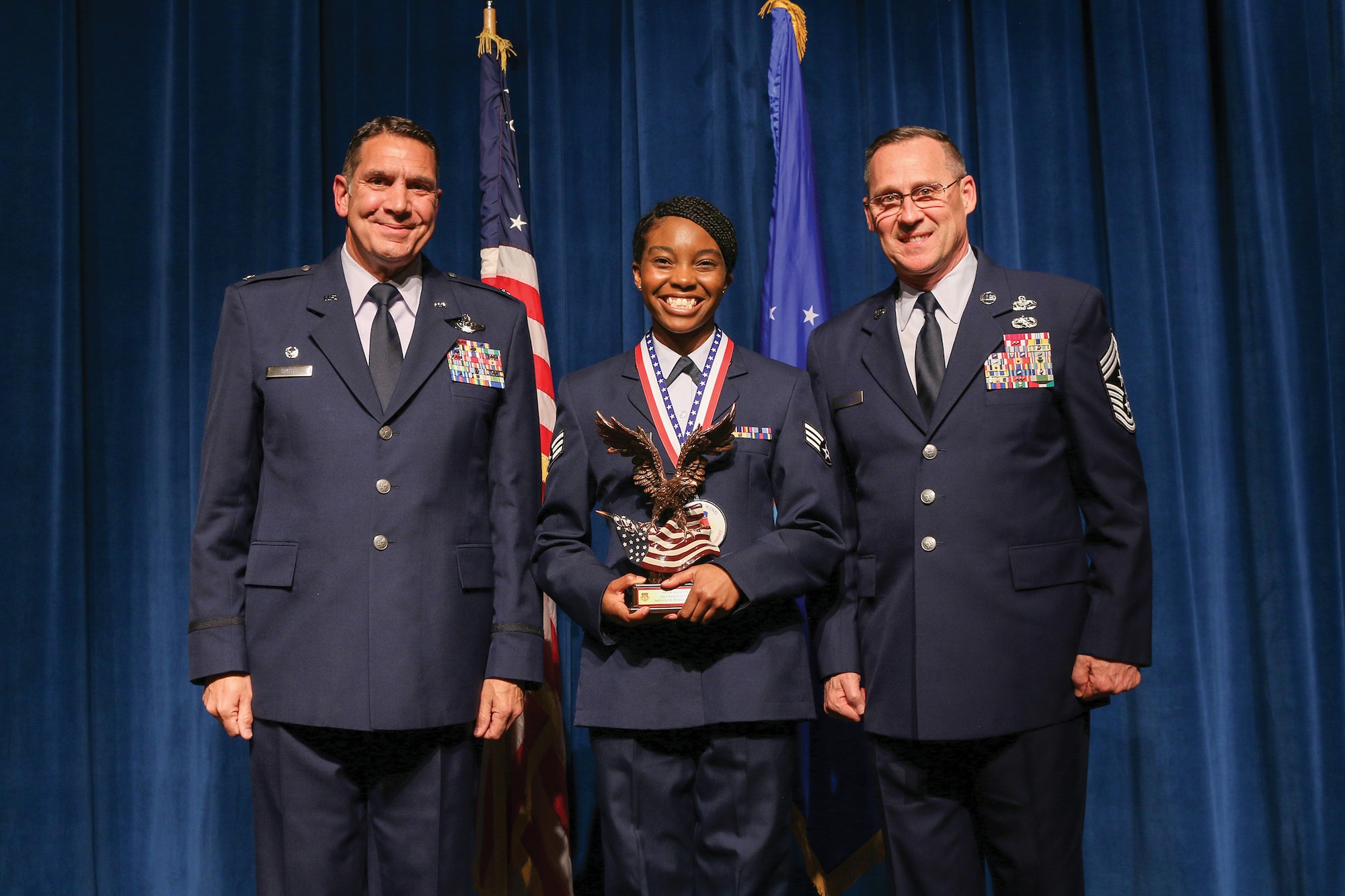 Senior Airman Cicely McWhorter, 87th Aerial Port Squadron, accepts the 2021 Airman of the Year award during the 445th Airlift Wing's Annual Awards Recognition Ceremony April 2, 2022. The event recognized 34 nominees. Col. Raymond Smith, 445th AW commander and Chief Master Sgt. Christopher Williams, presented medallions to nominees and a trophy to the winners. Mrs. Stephanie Smith, 445th Airlift Wing Key Spouse Mentor and wife of Col. Smith, presented the spouse and youth nominees their medallions and trophies to the winners.