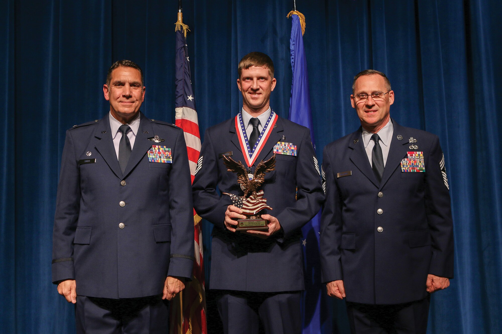 Tech. Sgt. Zachary Tschuor, 445th Aeromedical Staging Squadron, accepts the 2021 NCO of the Year award during the 445th Airlift Wing's Annual Awards Recognition Ceremony April 2, 2022. The event recognized 34 nominees. Col. Raymond Smith, 445th AW commander and Chief Master Sgt. Christopher Williams, presented medallions to nominees and a trophy to the winners. Mrs. Stephanie Smith, 445th Airlift Wing Key Spouse Mentor and wife of Col. Smith, presented the spouse and youth nominees their medallions and trophies to the winners.