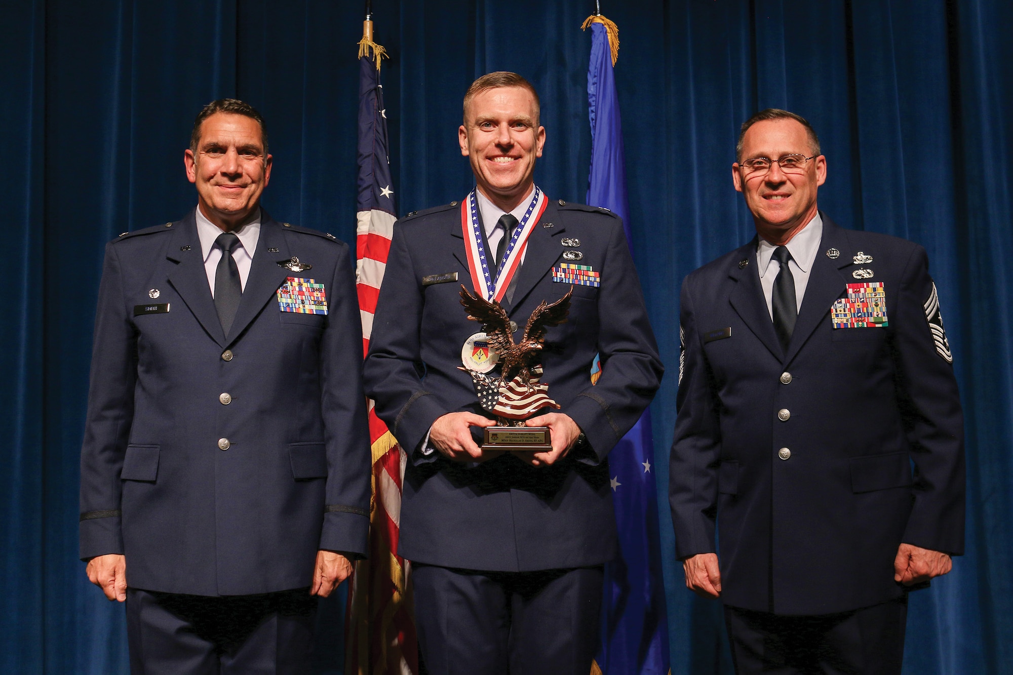 Senior Master Sgt. Nicholas Akins, 87th Aerial Port Squadron, accepts the 2021 Senior NCO of the Year award during the 445th Airlift Wing's Annual Awards Recognition Ceremony April 2, 2022. The event recognized 34 nominees. Col. Raymond Smith, 445th AW commander and Chief Master Sgt. Christopher Williams, presented medallions to nominees and a trophy to the winners. Mrs. Stephanie Smith, 445th Airlift Wing Key Spouse Mentor and wife of Col. Smith, presented the spouse and youth nominees their medallions and trophies to the winners.