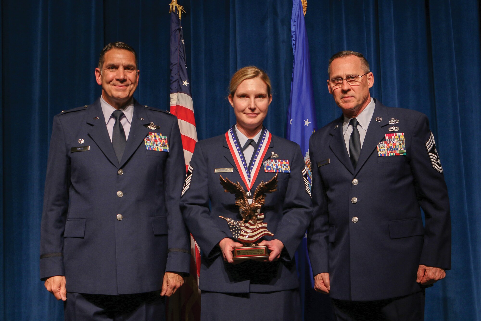 Senior Master Sgt. Brooke Howells, 445th Maintenance Squadron, accepts the 2021 First Sergeant of the Year award during the 445th Airlift Wing's Annual Awards Recognition Ceremony April 2, 2022. The event recognized 34 nominees. Col. Raymond Smith, 445th AW commander and Chief Master Sgt. Christopher Williams, presented medallions to nominees and a trophy to the winners. Mrs. Stephanie Smith, 445th Airlift Wing Key Spouse Mentor and wife of Col. Smith, presented the spouse and youth nominees their medallions and trophies to the winners.