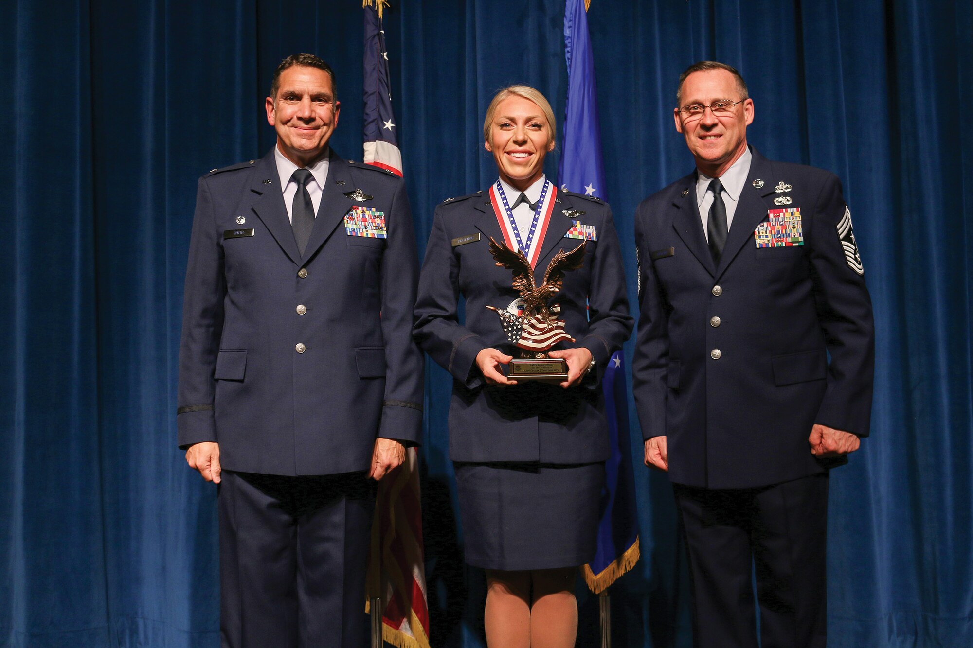 Capt. Cecilia Photinos, 445th Operations Support Squadron, accepts the 2021 Company Grade Officer of the Year award during the 445th Airlift Wing's Annual Awards Recognition Ceremony April 2, 2022. The event recognized 34 nominees. Col. Raymond Smith, 445th AW commander and Chief Master Sgt. Christopher Williams, presented medallions to nominees and a trophy to the winners. Mrs. Stephanie Smith, 445th Airlift Wing Key Spouse Mentor and wife of Col. Smith, presented the spouse and youth nominees their medallions and trophies to the winners.
