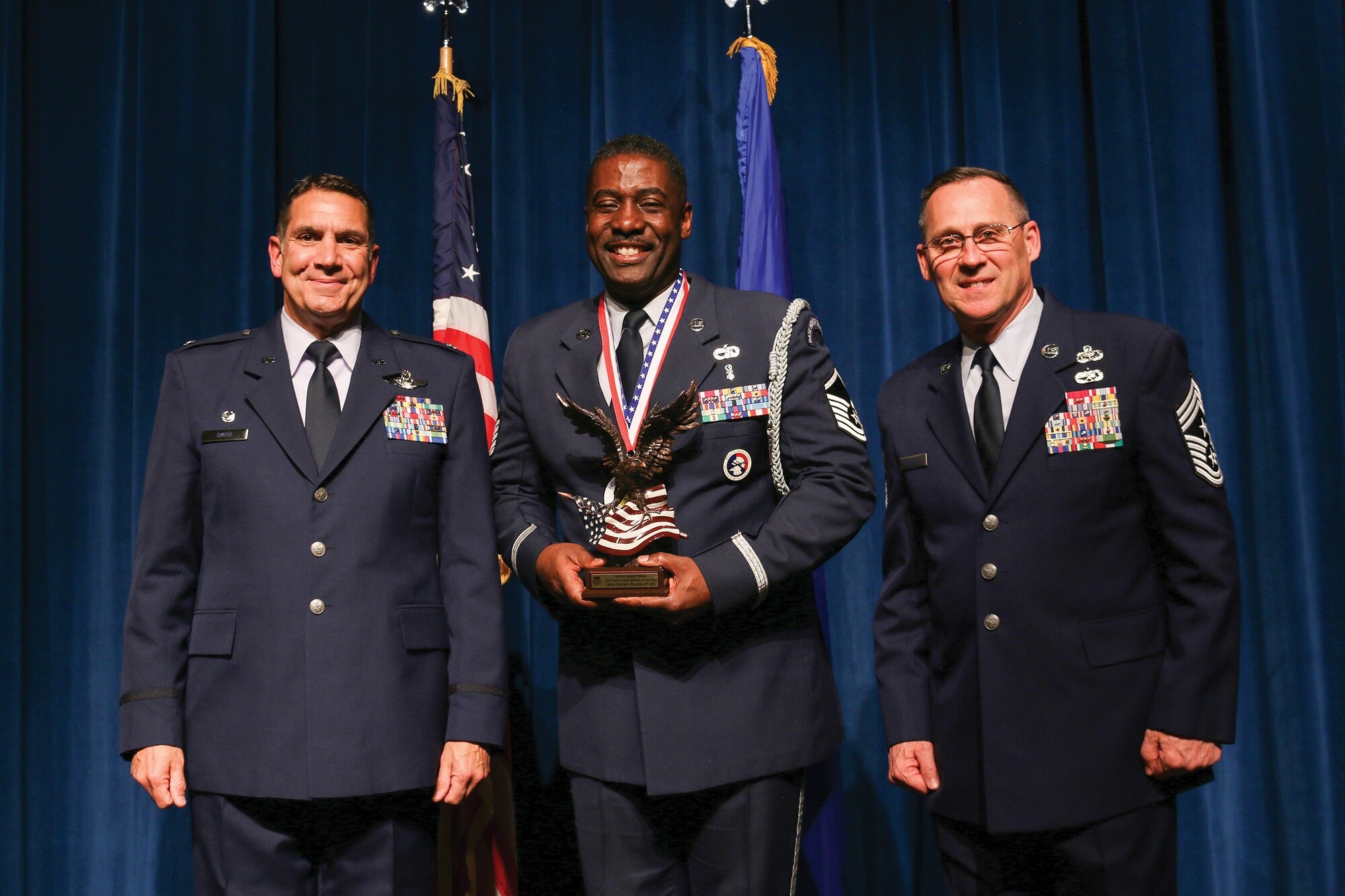 Master Sgt. Victor Walker, 87th Aerial Port Squadron, accepts the 2021 Honor Guard Member of the Year award during the 445th Airlift Wing's Annual Awards Recognition Ceremony April 2, 2022. The event recognized 34 nominees. Col. Raymond Smith, 445th AW commander and Chief Master Sgt. Christopher Williams, presented medallions to nominees and a trophy to the winners. Mrs. Stephanie Smith, 445th Airlift Wing Key Spouse Mentor and wife of Col. Smith, presented the spouse and youth nominees their medallions and trophies to the winners.