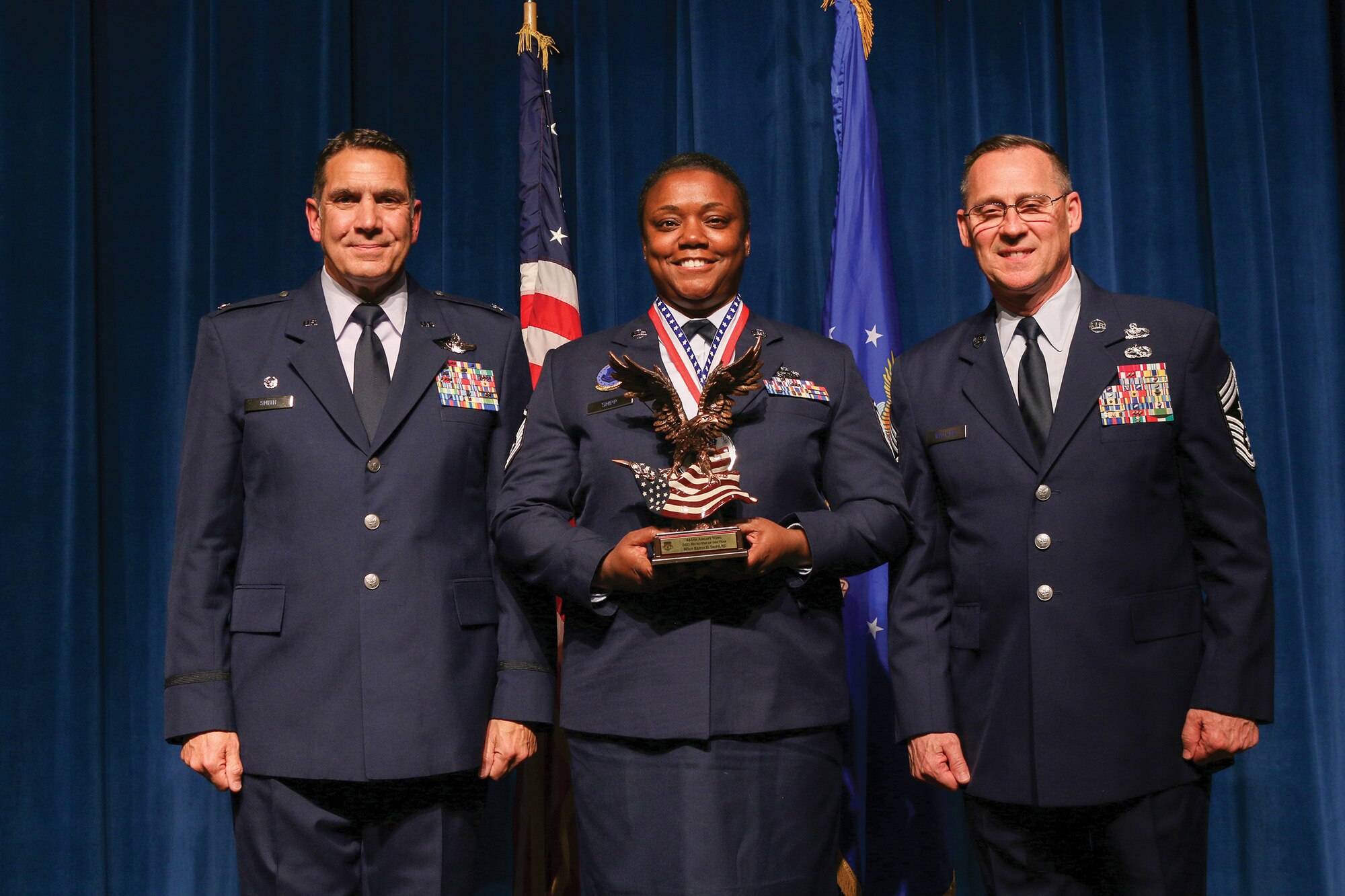 Master Sgt. Kenya Shipp, 445th Airlift Wing Recruiting Squadron, accepts the 2021 Recruiter of the Year award during the 445th Airlift Wing's Annual Awards Recognition Ceremony April 2, 2022. The event recognized 34 nominees. Col. Raymond Smith, 445th AW commander and Chief Master Sgt. Christopher Williams, presented medallions to nominees and a trophy to the winners. Mrs. Stephanie Smith, 445th Airlift Wing Key Spouse Mentor and wife of Col. Smith, presented the spouse and youth nominees their medallions and trophies to the winners.