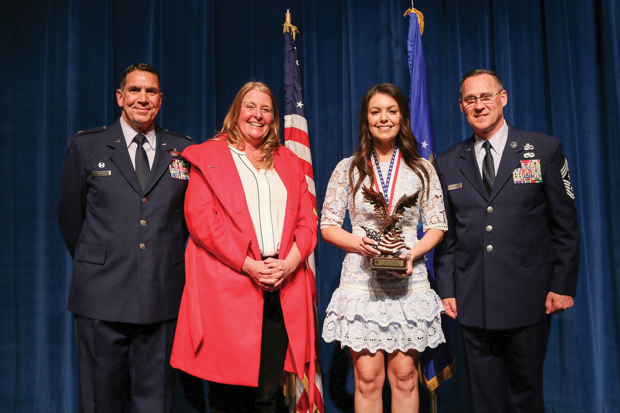 Mrs. Ann McCaslin, spouse of Senior Master Sgt. Sean McCaslin, 445th Security Forces Squadron, accepts the 2021 Spouse of the Year award during the 445th Airlift Wing's Annual Awards Recognition Ceremony April 2, 2022. The event recognized 34 nominees. Col. Raymond Smith, 445th AW commander and Chief Master Sgt. Christopher Williams, presented medallions to nominees and a trophy to the winners. Mrs. Stephanie Smith, 445th Airlift Wing Key Spouse Mentor and wife of Col. Smith, presented the spouse and youth nominees their medallions and trophies to the winners.