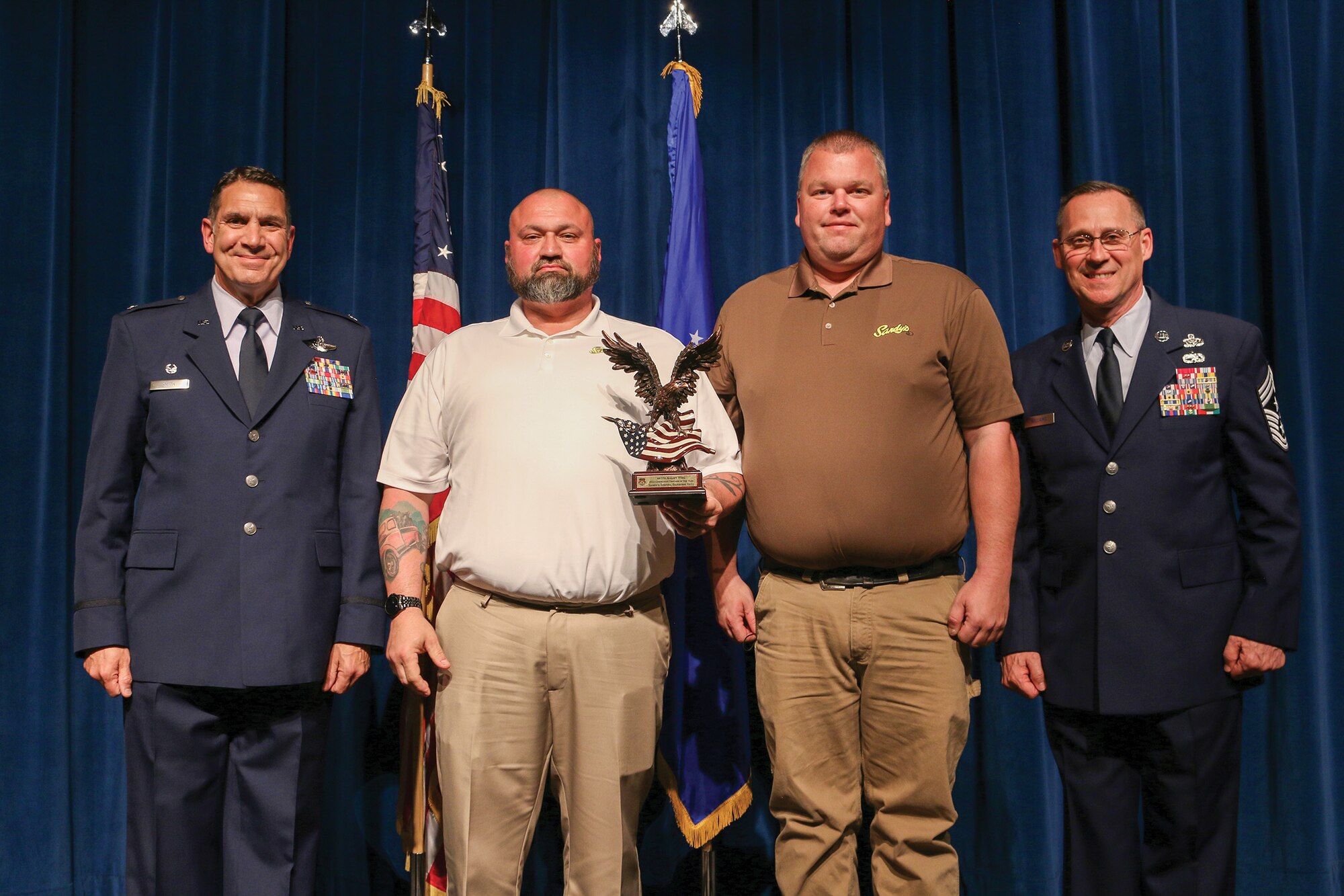 Richard Dunn and Ryan Arnett, representatives of Sandy's Towing and Recovery, accept the 2021 Community Partner of the Year award for their company during the 445th Airlift Wing's Annual Awards Recognition Ceremony April 2, 2022. The event recognized 34 nominees.