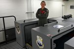 Staff Sgt. Audrey Levey, 155th Air Refueling Wing boom operator, next to a Boom Operating Simulator System, March 25, 2022, at Lincoln Air Force Base, Neb.
