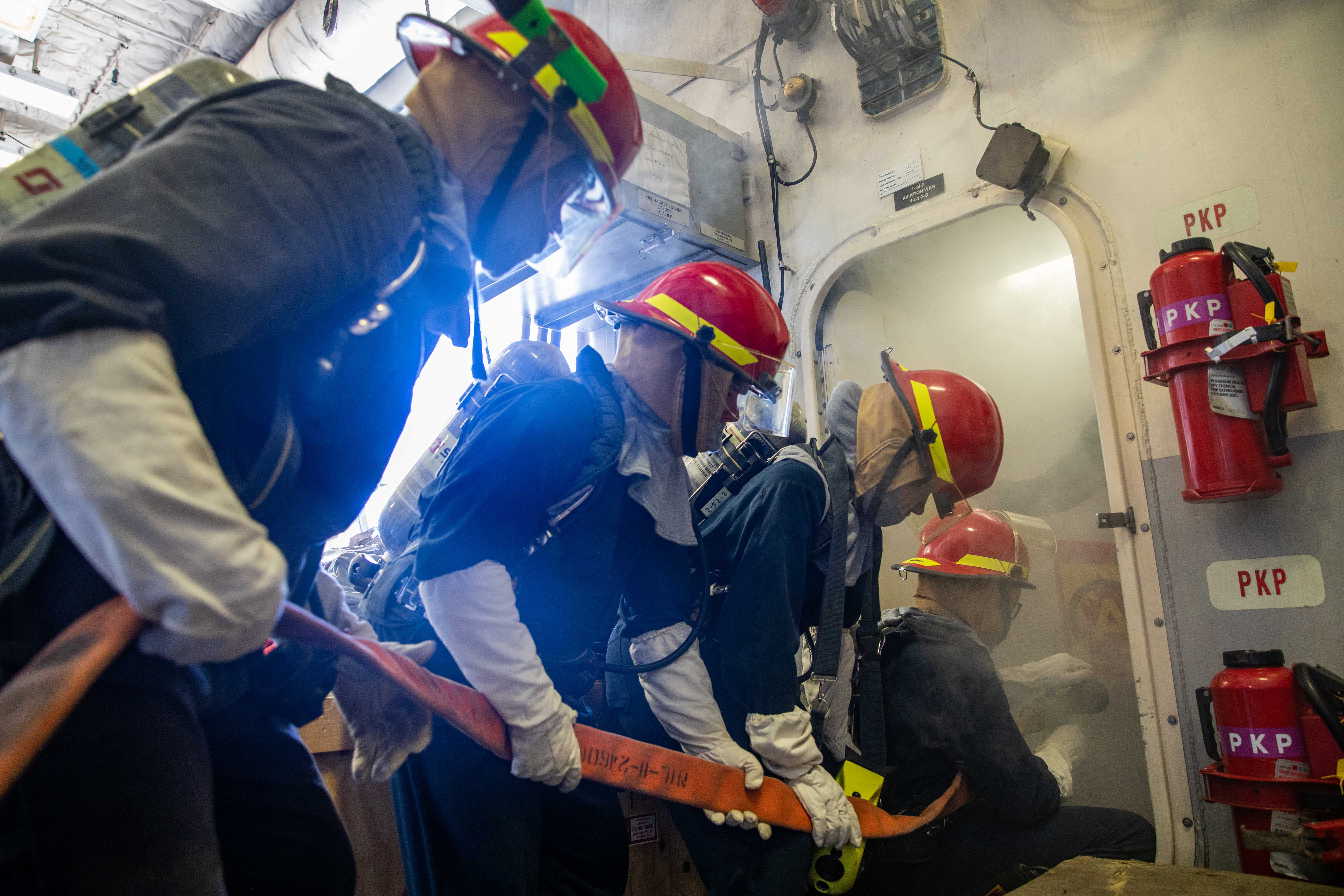 Sailors fight a simulated fire during a damage control drill aboard the Freedom-variant littoral combat ship USS Milwaukee (LCS 5), March 29, 2022.