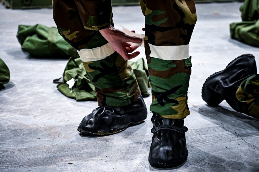 A U.S. Air Force Airman from the 305th Air Mobility Wing applies tape to mission oriented protective posture gear, demonstrating the ability to survive and operate in a contested environment during a readiness exercise at Joint Base McGuire-Dix-Lakehurst, New Jersey, Apr. 3, 2022. Training exercises reinforce Airmen readiness and deliberately strengthen Air Mobility Command’s warfighting culture in order to provide unrivaled Rapid Global Mobility capable of protecting and sustaining the Joint Force.