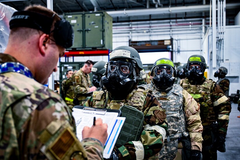 A U.S. Air Force Airman from the 305th Air Mobility Wing provides mission oriented protective posture gear inspection to multiple Airmen, demonstrating the ability to survive and operate in a contested environment during a readiness exercise at Joint Base McGuire-Dix-Lakehurst, New Jersey, Apr. 3, 2022. Training exercises reinforce Airmen readiness and deliberately strengthen Air Mobility Command’s warfighting culture in order to provide unrivaled Rapid Global Mobility capable of protecting and sustaining the Joint Force.