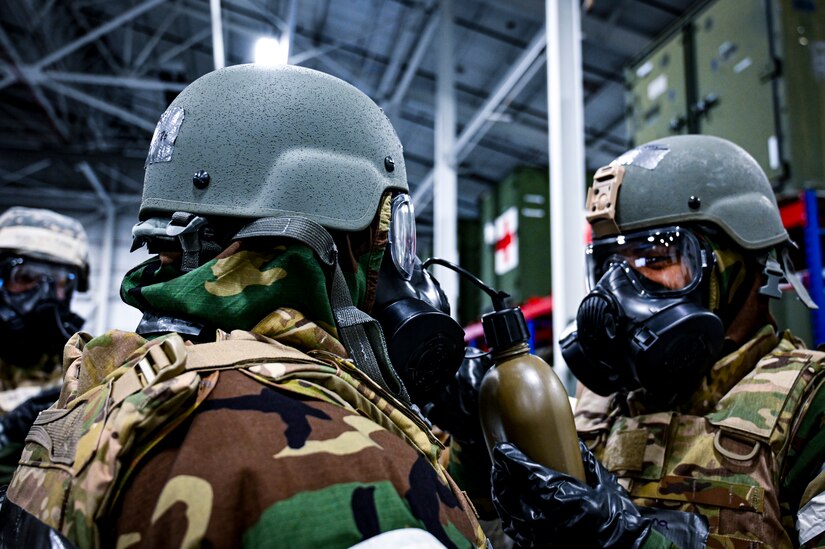 A U.S. Air Force Airman from the 514th Air Mobility Wing drinks from a canteen through a mission oriented protective posture gear protective mask, demonstrating the ability to survive and operate in a contested pduring a readiness exercise at Joint Base McGuire-Dix-Lakehurst, New Jersey, Apr. 3, 2022. Training exercises reinforce Airmen readiness and deliberately strengthen Air Mobility Command’s warfighting culture in order to provide unrivaled Rapid Global Mobility capable of protecting and sustaining the Joint Force.