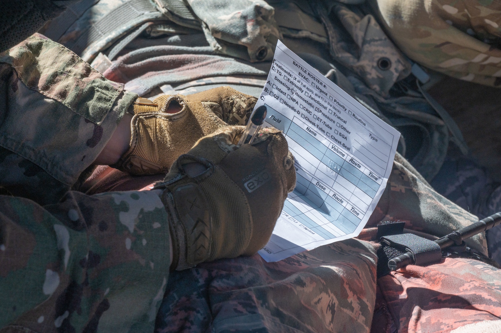 Staff Sgt. Jennifer Torres, 436th Security Forces Squadron response force leader, fills in a Tactical Combat Casualty Care card during a Tactics and Leadership Nexus exercise on Dover Air Force Base, Delaware, March 18, 2022. The goal of TALN is to enhance readiness and train multi-capable Airmen. Recent additions to the course include land navigation, active shooter drills and unexploded ordnance exercises. (U.S. Air Force photo by Airman 1st Class Cydney Lee)