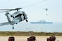 A general purpose amphibious assault ship is loaded with munitions via helicopter.