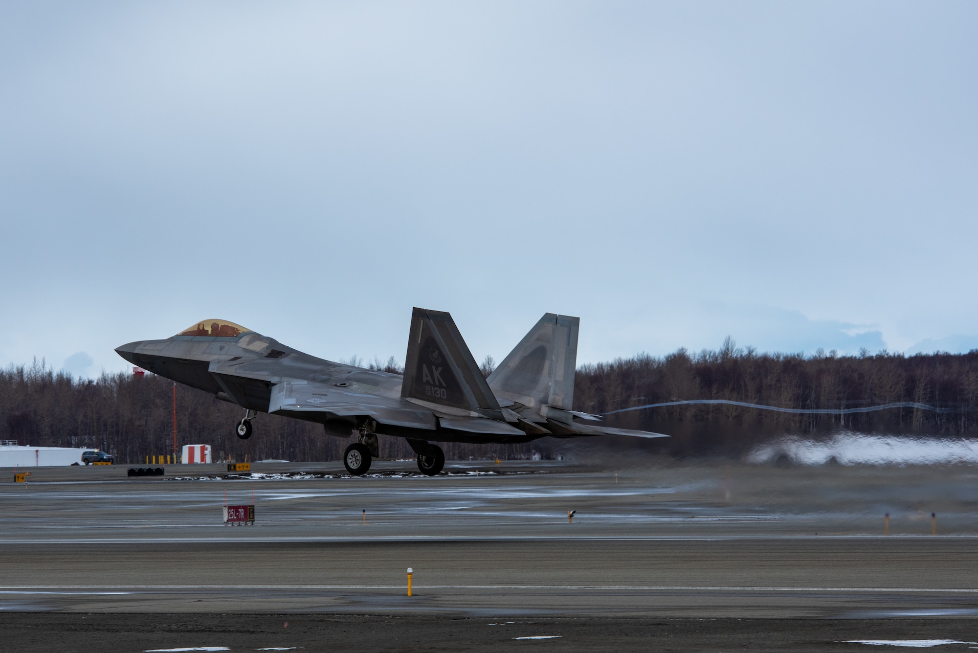 A photo of an F-22 Raptor taking off from Ted Stevens Anchorage International Airport.