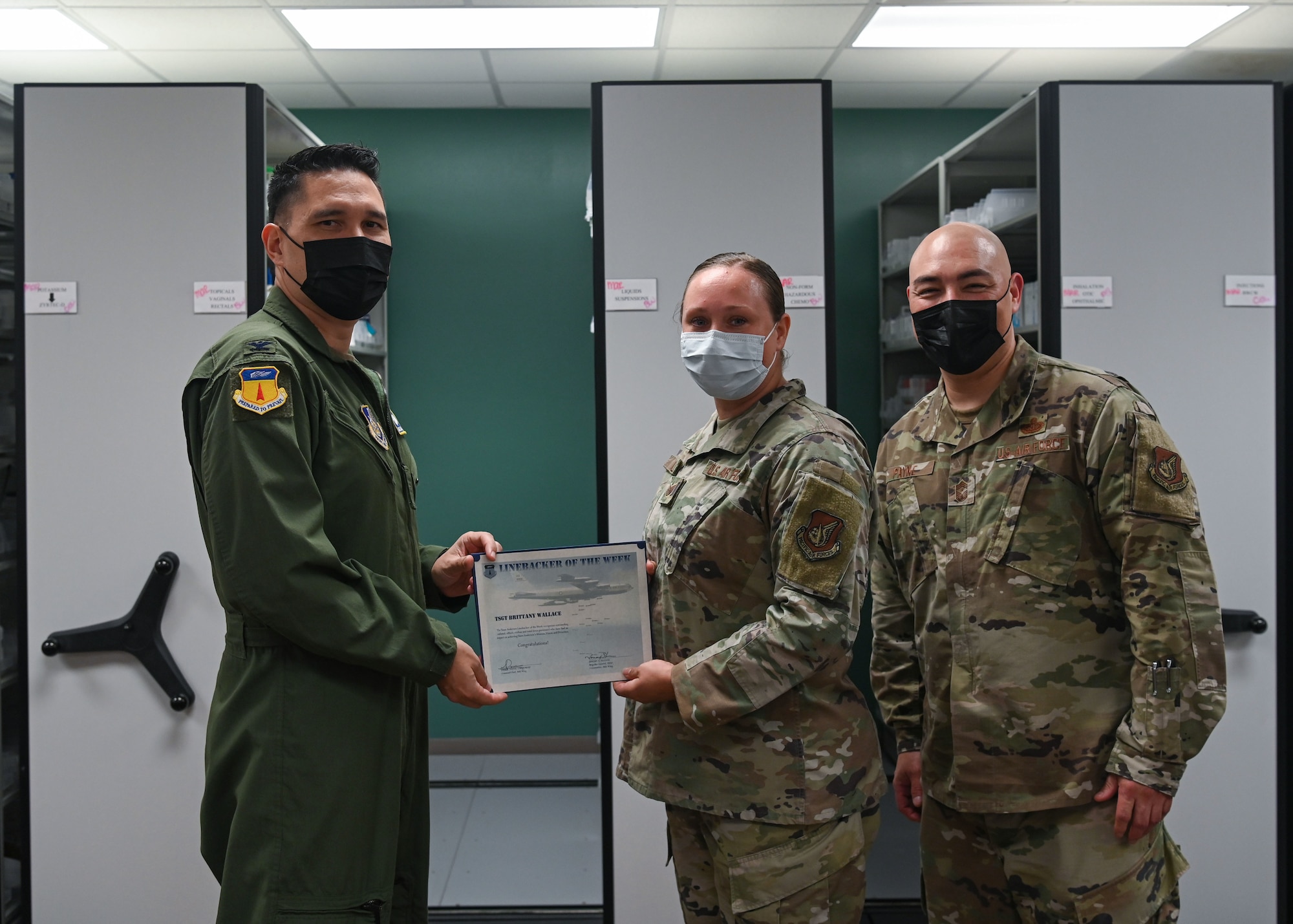 U.S. Air Force Col. David Aragon, 36th Wing vice commander, presents Linebacker of the Week award to U.S. Air Force Tech. Sgt. Brittany Wallace, pharmacy flight chief of the 36th Healthcare Operations Squadron, at Andersen Air Force Base, Guam, March 30, 2022.