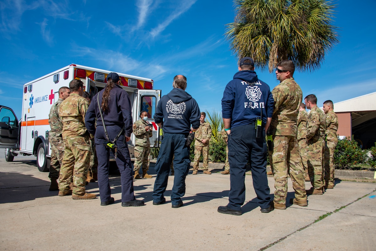 group of Airmen standing behind ambulance