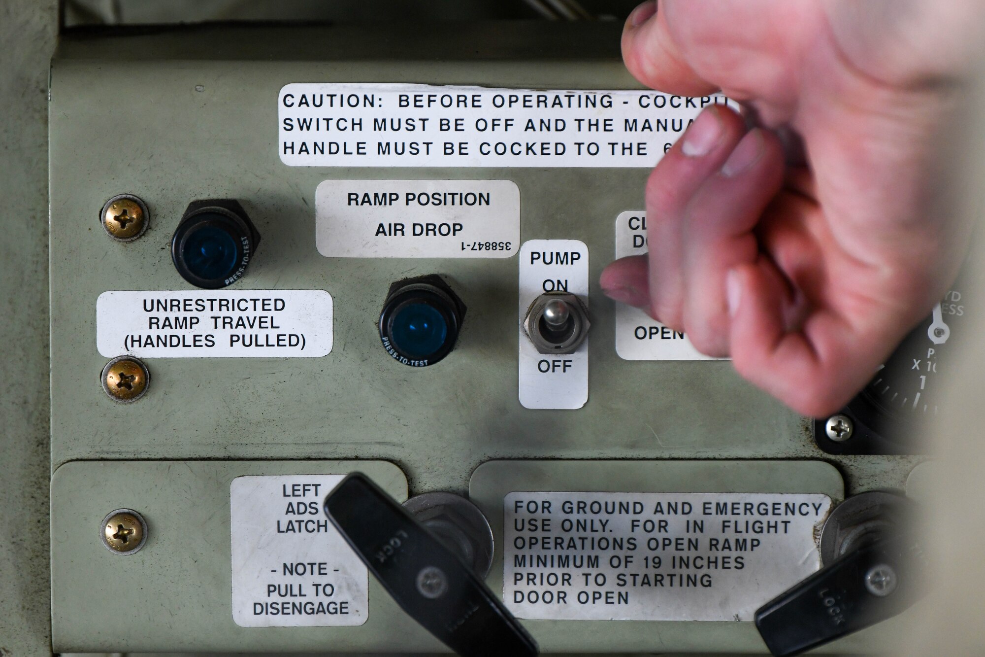 Airman flips a switch while performing pre-flight duties