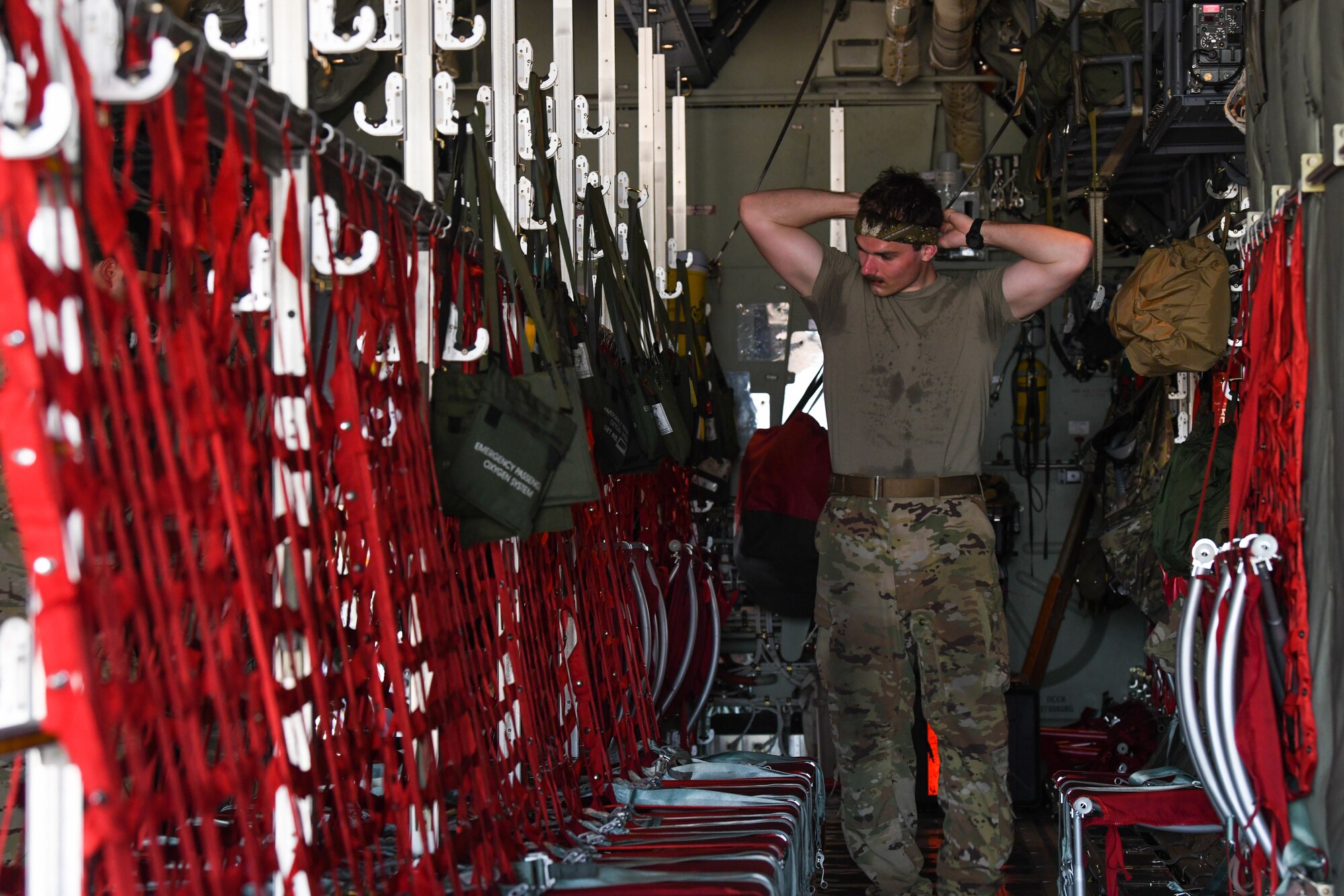 Airman wraps a bandana around his head while performing pre-flight duties