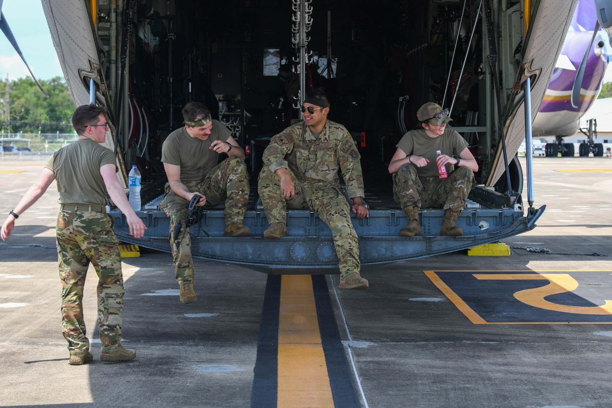 Airmen rest on a C-130J Super Hercules loading dock