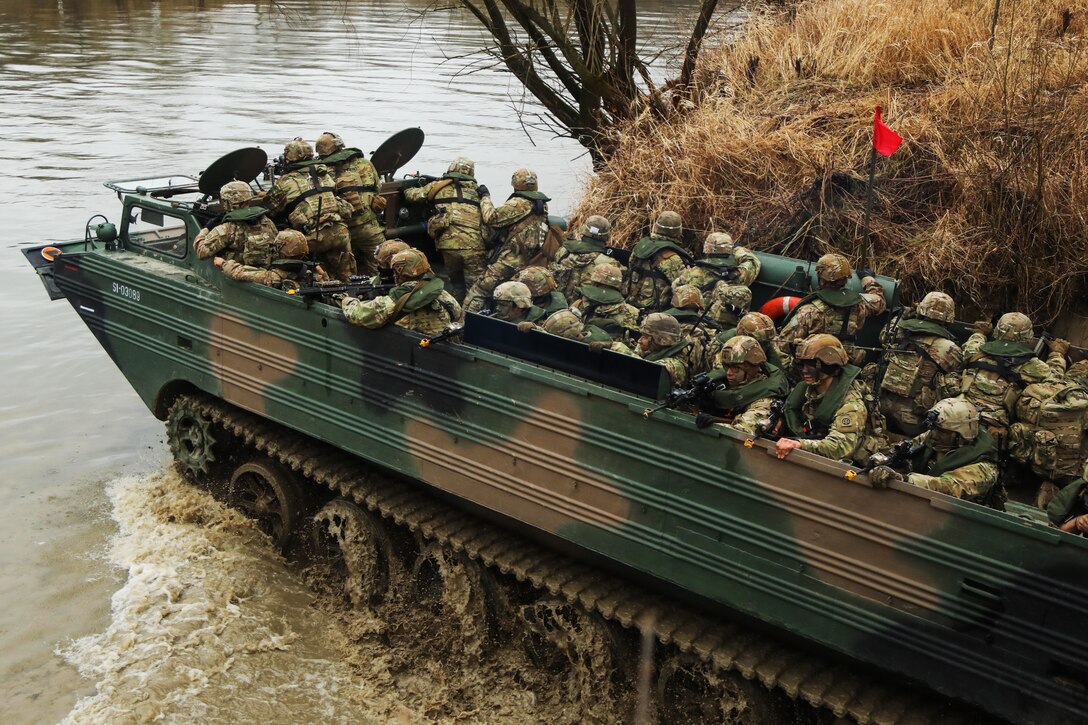 Soldiers cross a river in a Polish amphibious craft during a combined training exercise.