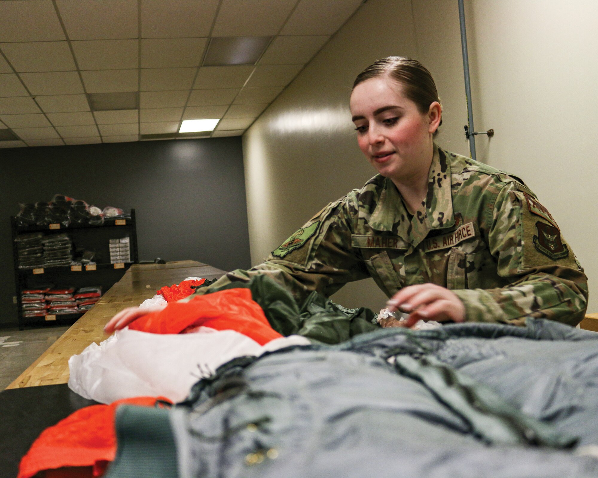 Senior Airman Sarah Maher, 445th Operations Support Squadron aircrew flight equipment technician, inspects an unserviceable parachute before it is replaced, March 14, 2022. Unserviceable parachutes are turned in to base supply and exchanged for new ones.