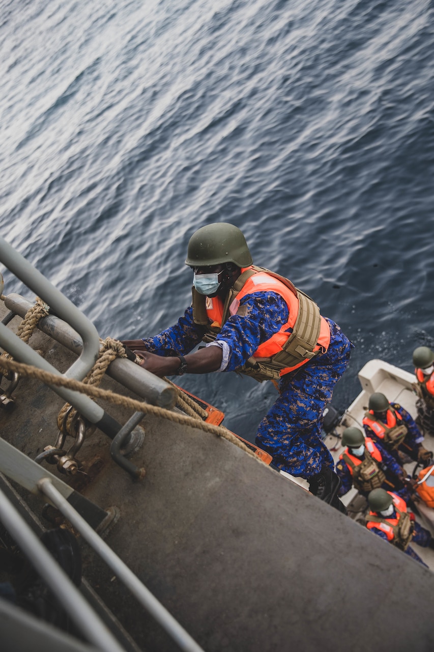 ATLANTIC OCEAN (March 13, 2022) A Navy Sailor with The Gambia military boards the Expeditionary Sea Base USS Hershel “Woody” Williams (ESB 4), as part of a training evolution during Exercise Obangame Express 2022, March 13, 2022. Obangame Express 2022, conducted by U.S. Forces Africa, is an at-sea maritime exercise designed to improve cooperation among participating nations in order to increase maritime safety and security in the Gulf of Guinea and West African coastal regions. (U.S. Marine Corps photo by Lance Cpl. Emma Gray)