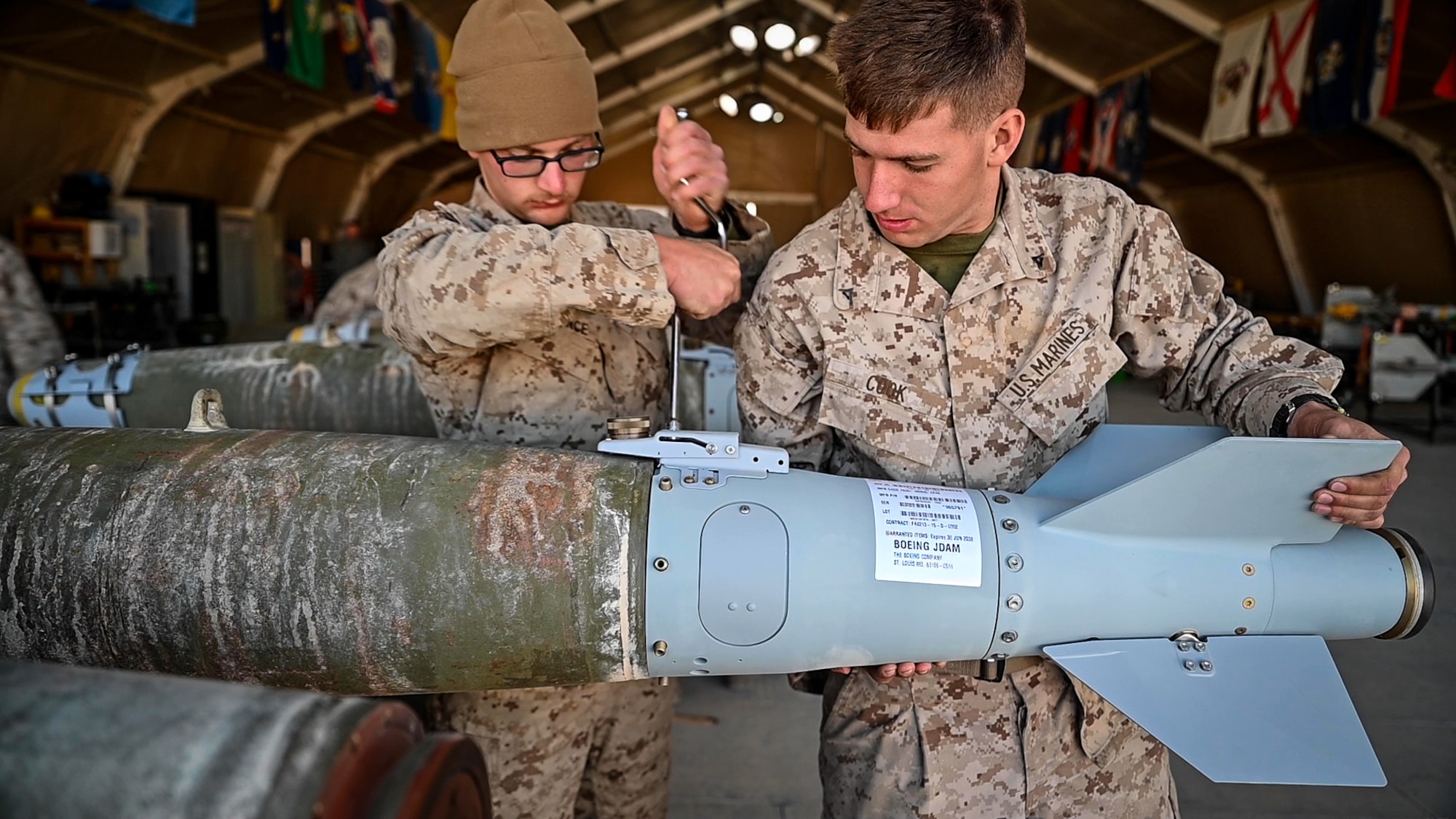 Marine Fighter Attack Squadron 115 aviation ordnance technicians prepare a U. S. Air Force Guided Bomb Unit 38 for employment on a U.S. Marine Corps F/A-18 Hornet proof of concept mission at an undisclosed location in Southwest Asia, March 14, 2022. VMFA-115 integrated with the 332d Air Expeditionary Wing to further interoperability between the two services by validating ordnance compatibilities between U.S. Air Force and U.S. Marine Corps assets during Operation Agile Spartan II. (U.S. Air Force Photo by Master Sgt. Christopher Parr)