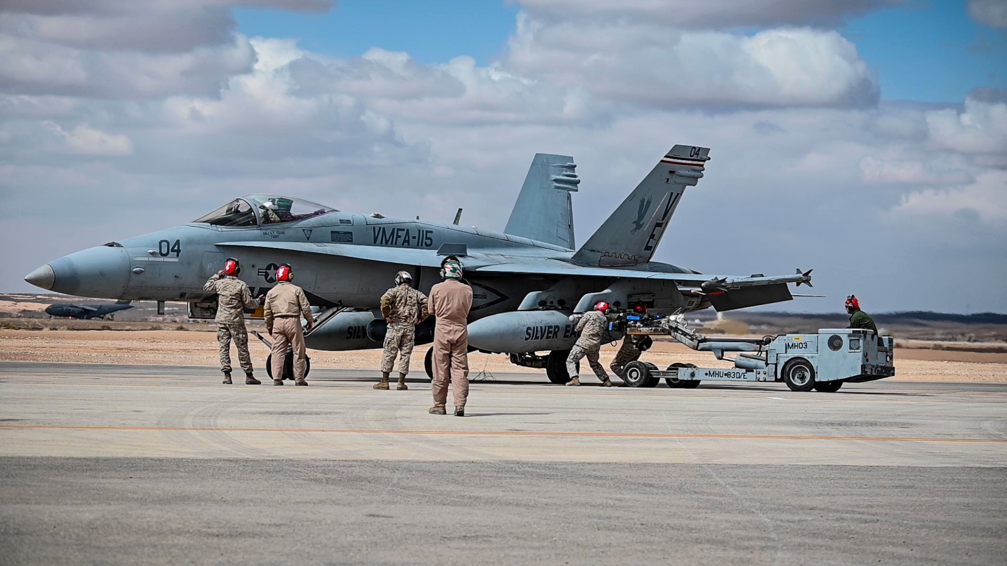 Marine Fighter Attack Squadron 115 aviation ordnance technicians load an adapted U. S. Air Force Guided Bomb Unit 38 onto a U.S. Marine Corps F/A-18 Hornet prior to a proof of concept mission at an undisclosed location in Southwest Asia, March 15, 2022. VMFA-115 integrated with the 332d Air Expeditionary Wing to further interoperability between the two services by validating ordnance compatibilities between U.S. Air Force and U.S. Marine Corps assets during Operation Agile Spartan II. (U.S. Air Force Photo by Master Sgt. Christopher Parr)