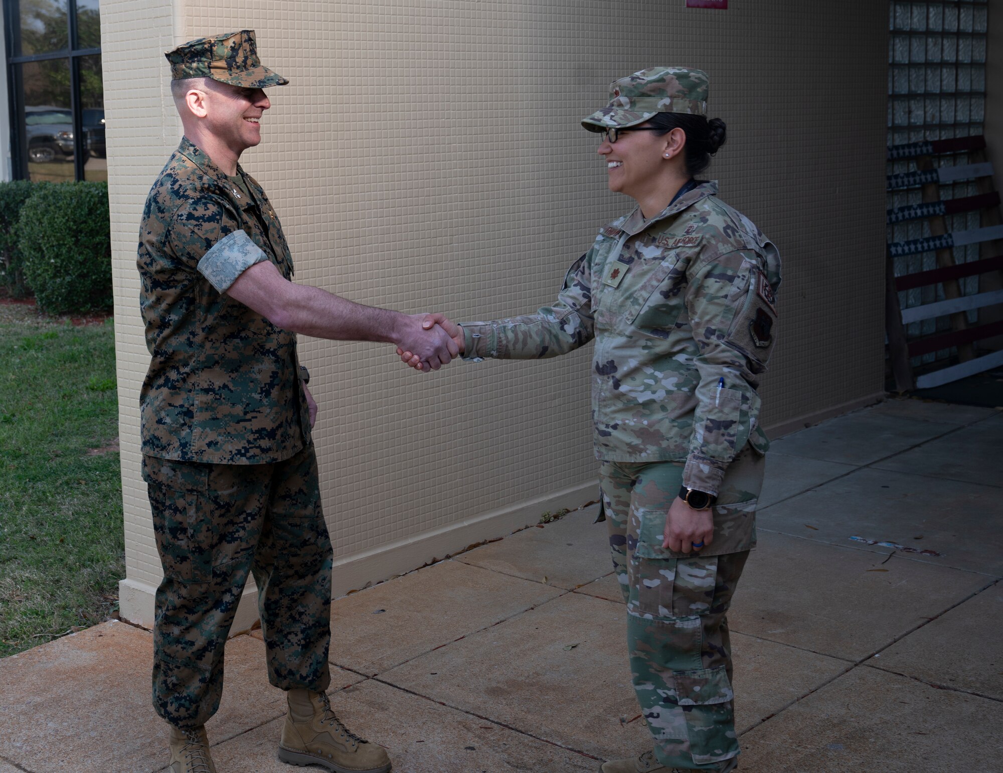 A Marine shakes hands with an Airman