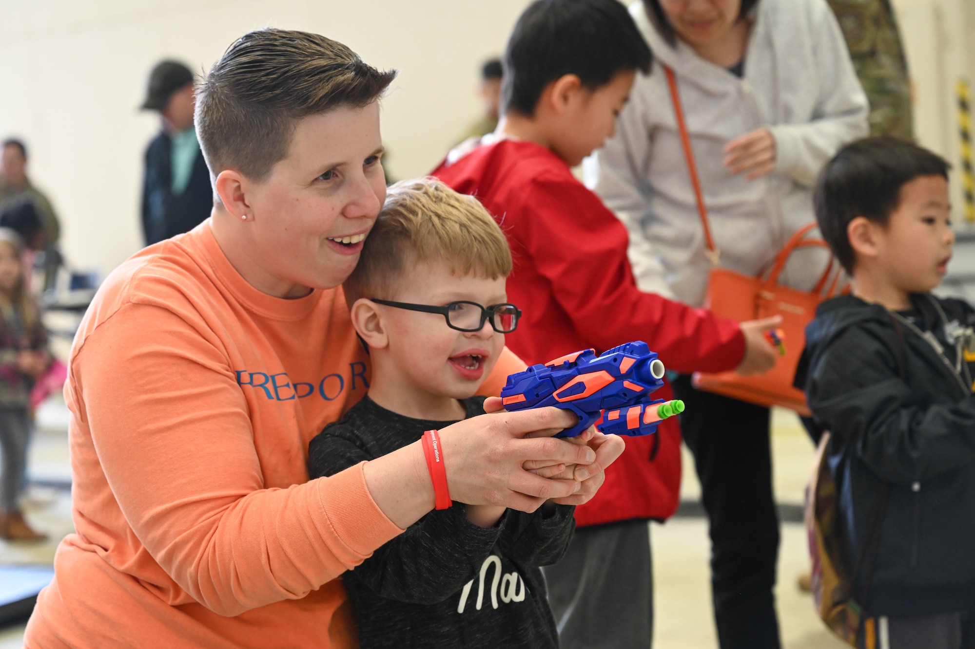 Master Sgt. Lindy Everton, 19th Mission Support Group enlisted executive officer, left, and her son, Parker Everton, 3, right, take aim with a toy gun
