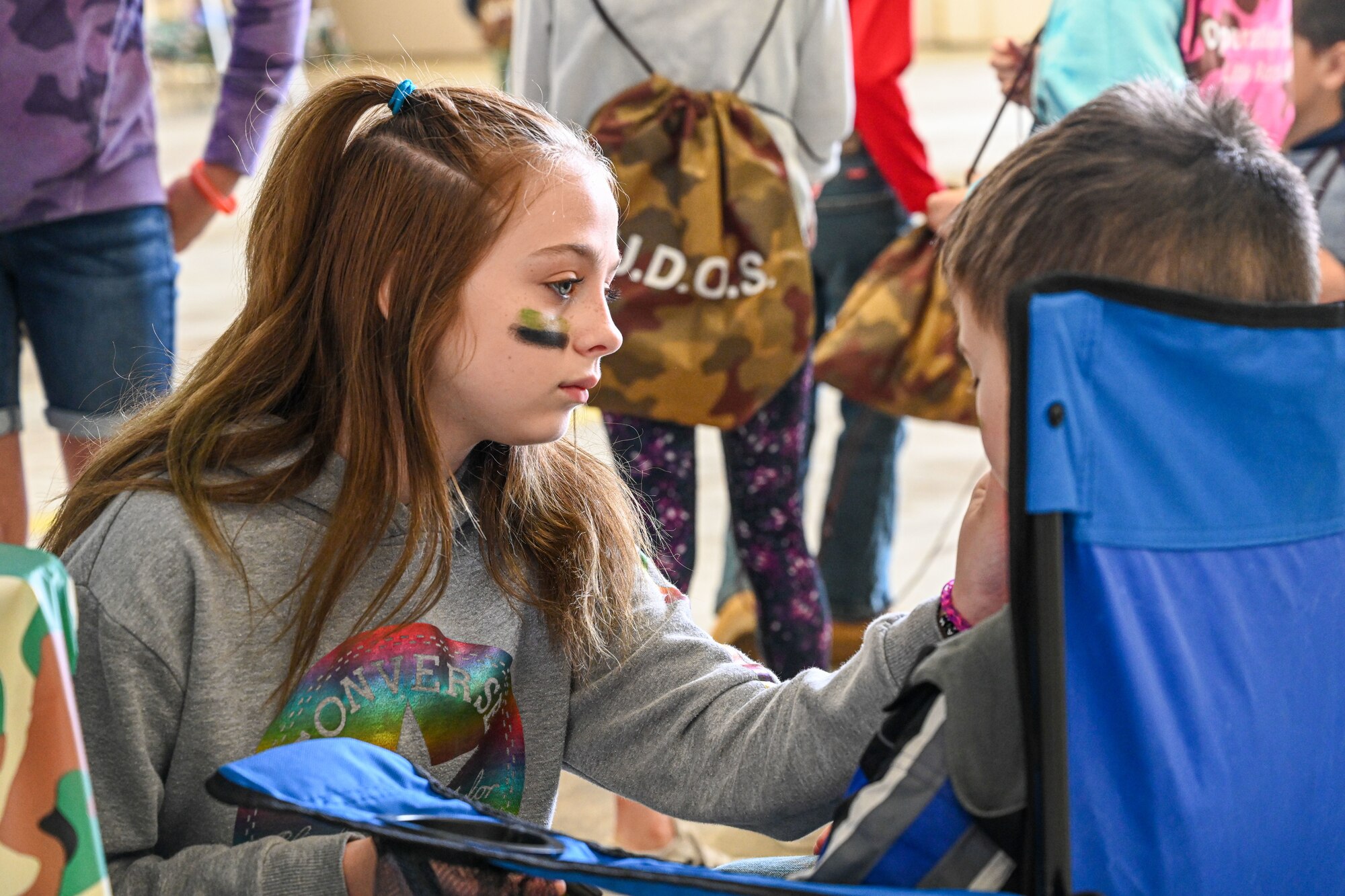 Children from Team Little Rock paint each other’s faces during a Kids Understanding Deployment Operations event