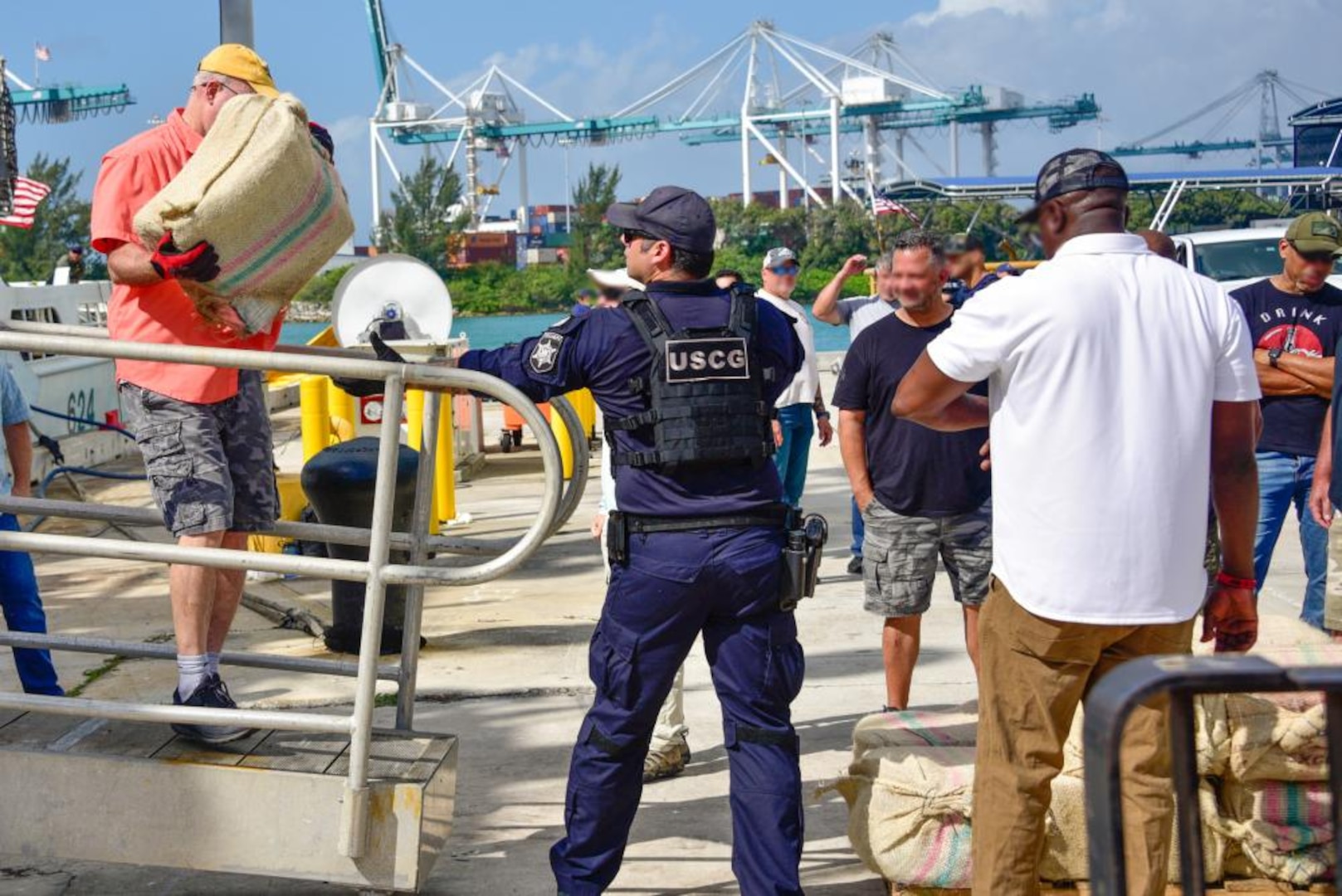 U.S. Coast Guard Cutter Dauntless' (WMEC-624) crewmembers offload bales of illegal narcotics on to pallet at Base Miami Beach, Florida, April 1, 2022. The Dauntless is homeported in Pensacola, Fla. (U.S. Coast Guard photo by Seaman Eric Rodriguez)