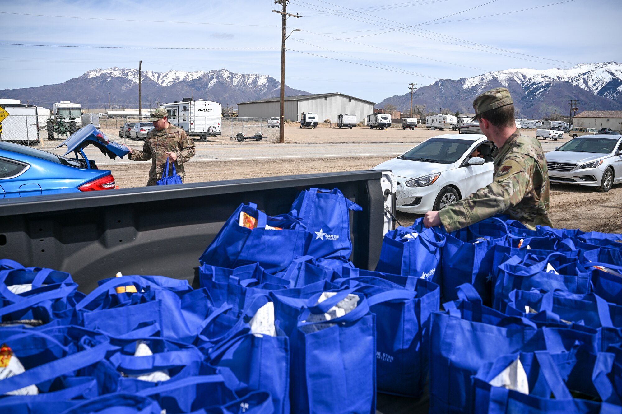 Master Sgt. Josue Palacios, 75th Logistics Readiness Squadron, left, and Airman 1st Class Wesley Benfield, 388th Munitions Squadron, load vehicles during a Nourish the Service event at Hill Air Force Base, Utah, April 1, 2022. The event provided new and soon-to-be parents with non-perishable food items, baby care supplies and resource information. (U.S. Air Force photo by R. Nial Bradshaw)