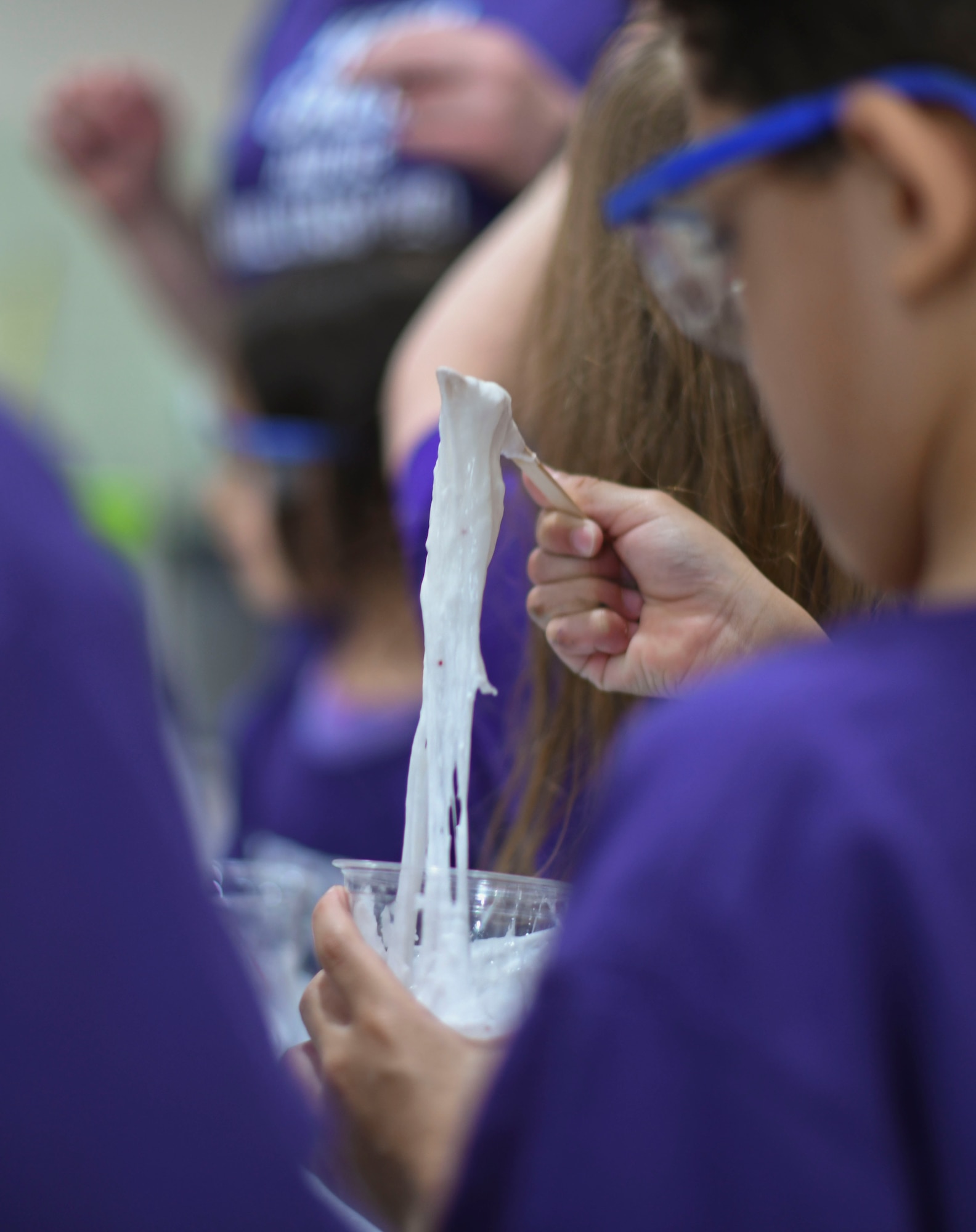 A student plays with the slime that he made.