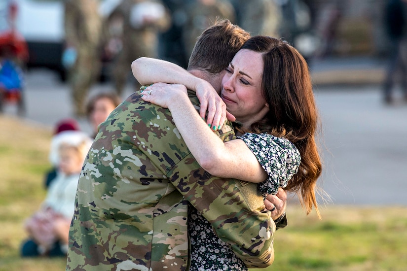 An airman hugs his wife.