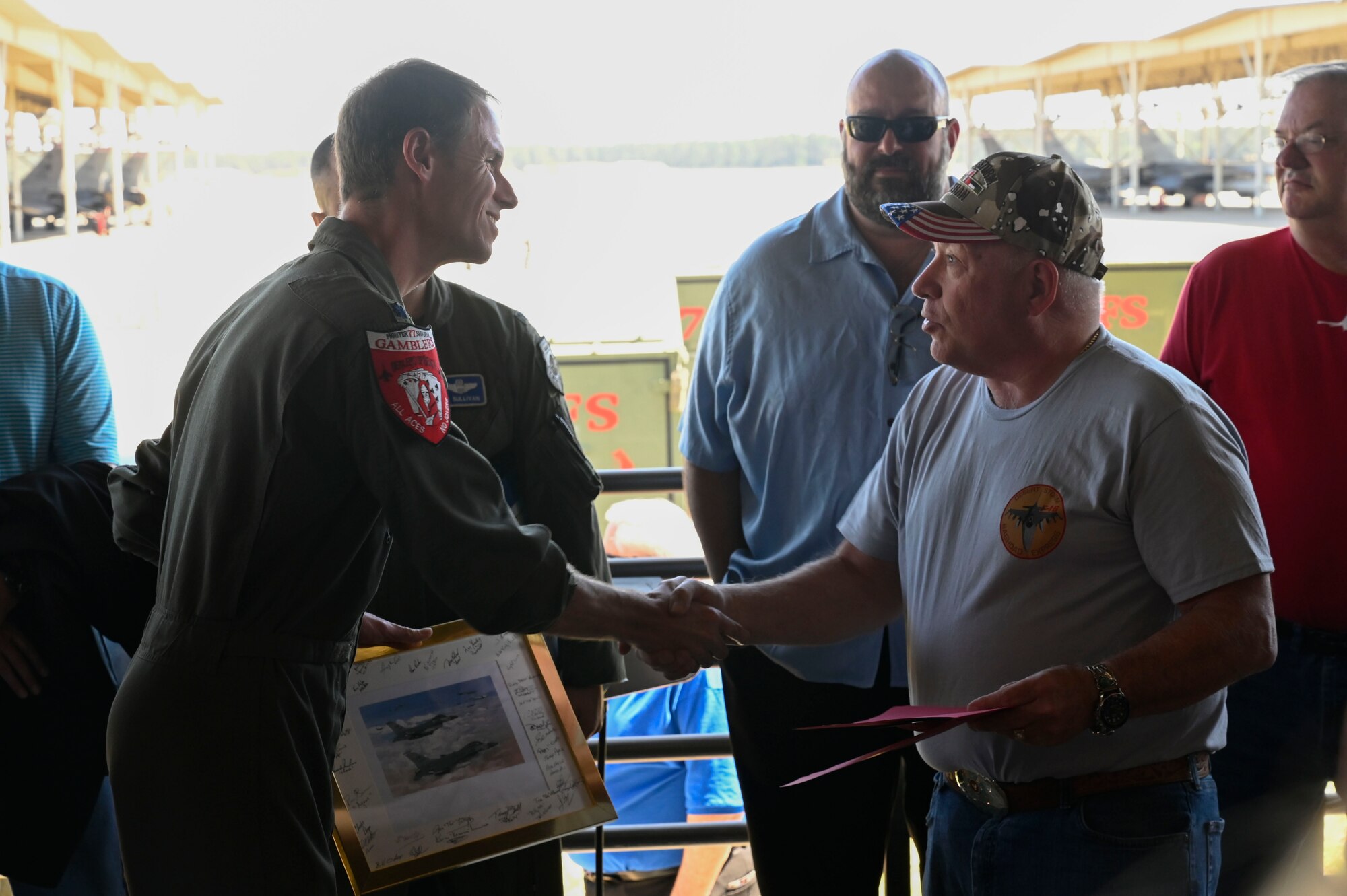 A photo of a pilot receiving a gift from a veteran