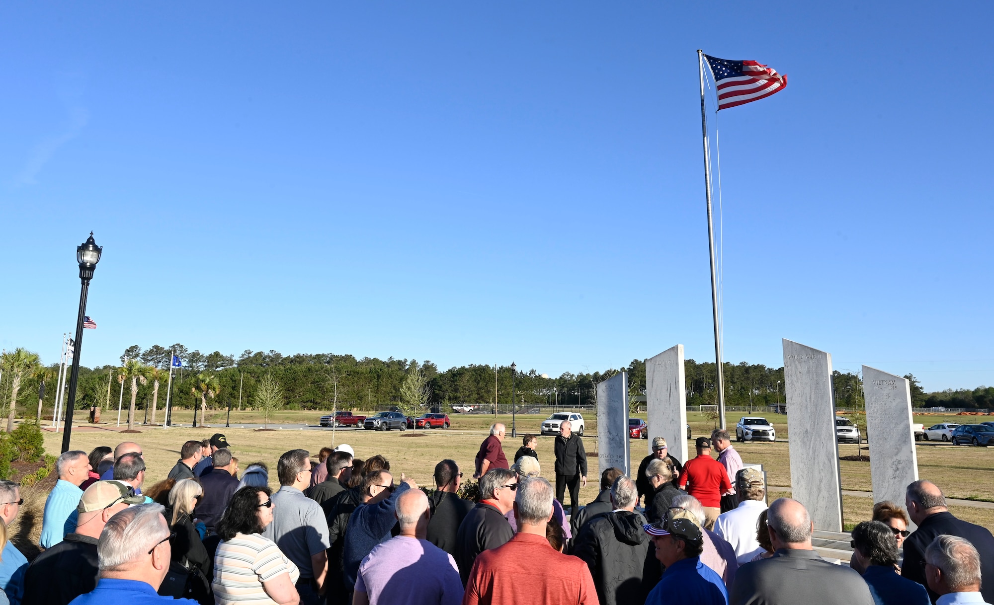 A photo of a group veterans standing in front of a monument