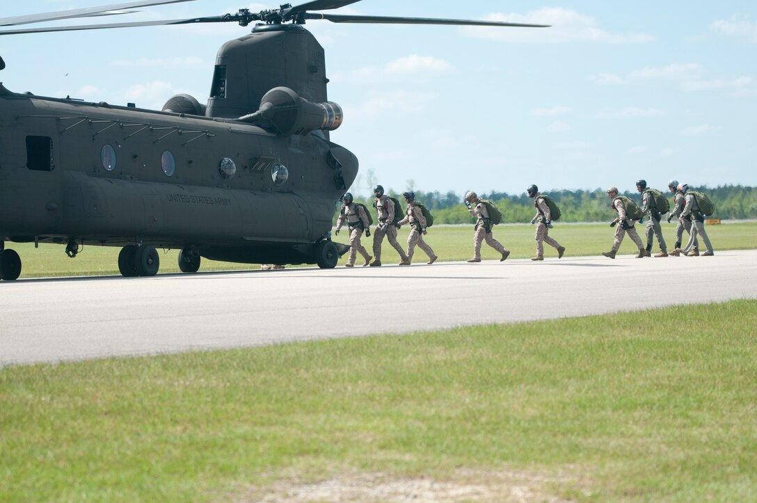 Service members board a helicopter from the rear.