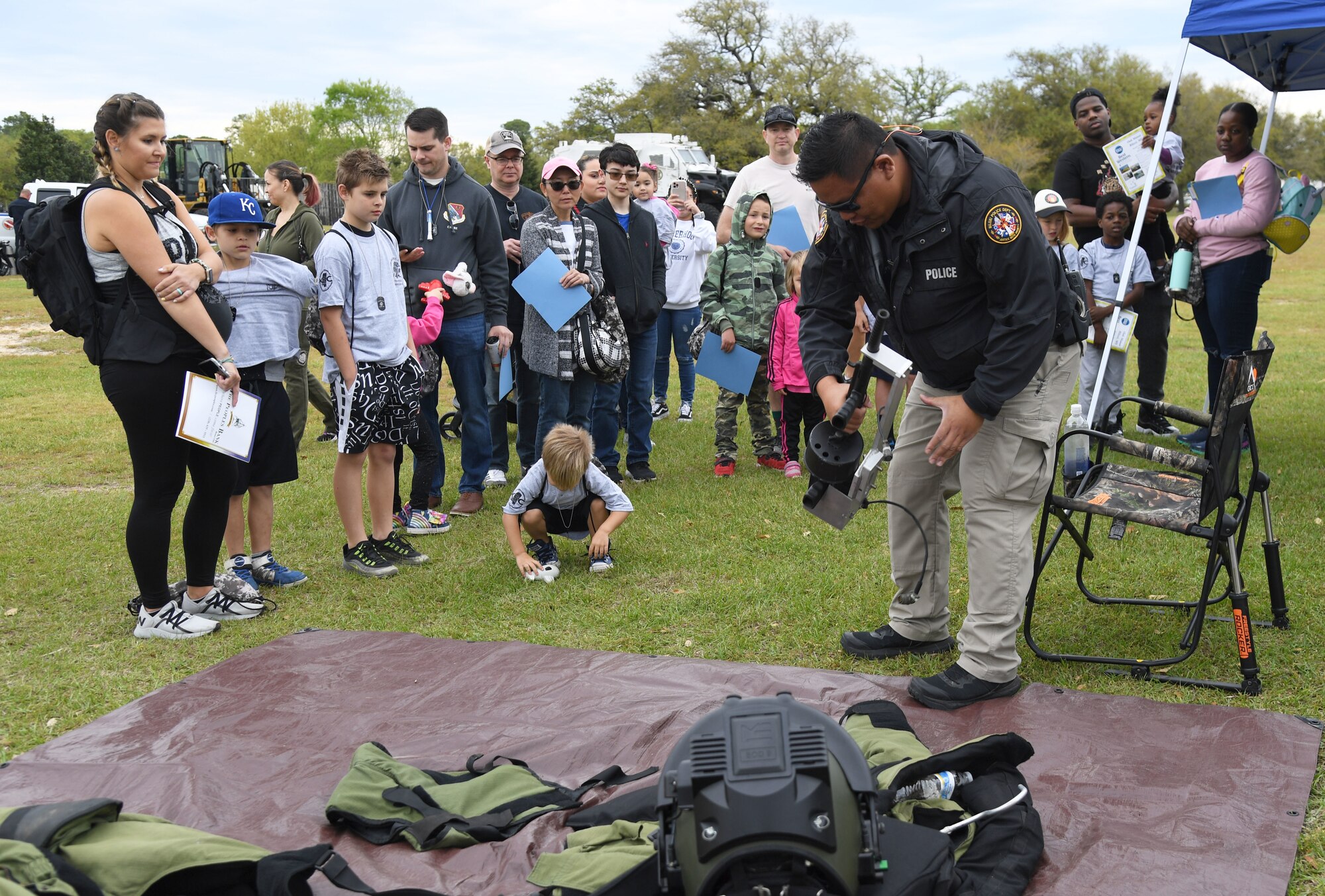 Keesler families receive a Biloxi Bomb Squad equipment brief during Operation Hero at Keesler Air Force Base, Mississippi, April 2, 2022. The event, hosted by the Airman and Family Readiness Center in recognition of the Month of the Military Child, gave military children a glimpse into the lives of deployed military members. Children received Operation Hero dog tags and t-shirts as they made their way through a mock deployment line as well as the opportunity to experience medical triage demonstrations, military working dog demonstrations and have their faces painted. (U.S. Air Force photo by Kemberly Groue)