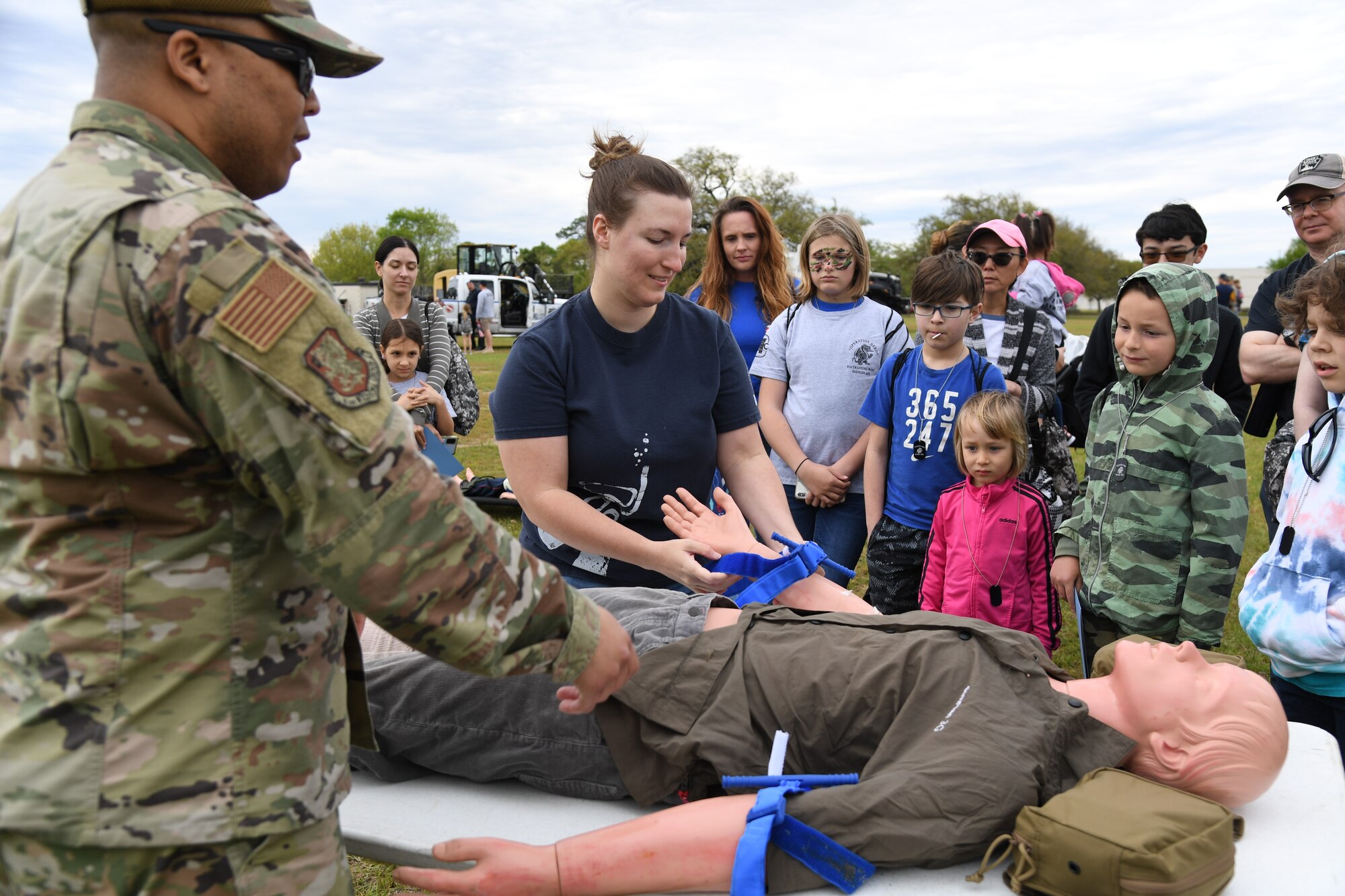U.S. Air Force Staff Sgt. Donald Mickens, 81st Medical Group life support training section chief, and Staff Sgt. Brittney Park, 81st Medical Support Squadron command support staff NCO in charge, provide a medical triage demonstration during Operation Hero at Keesler Air Force Base, Mississippi, April 2, 2022. The event, hosted by the Airman and Family Readiness Center in recognition of the Month of the Military Child, gave military children a glimpse into the lives of deployed military members. Children received Operation Hero dog tags and t-shirts as they made their way through a mock deployment line as well as the opportunity to experience a military working dog demonstration and have their faces painted. (U.S. Air Force photo by Kemberly Groue)