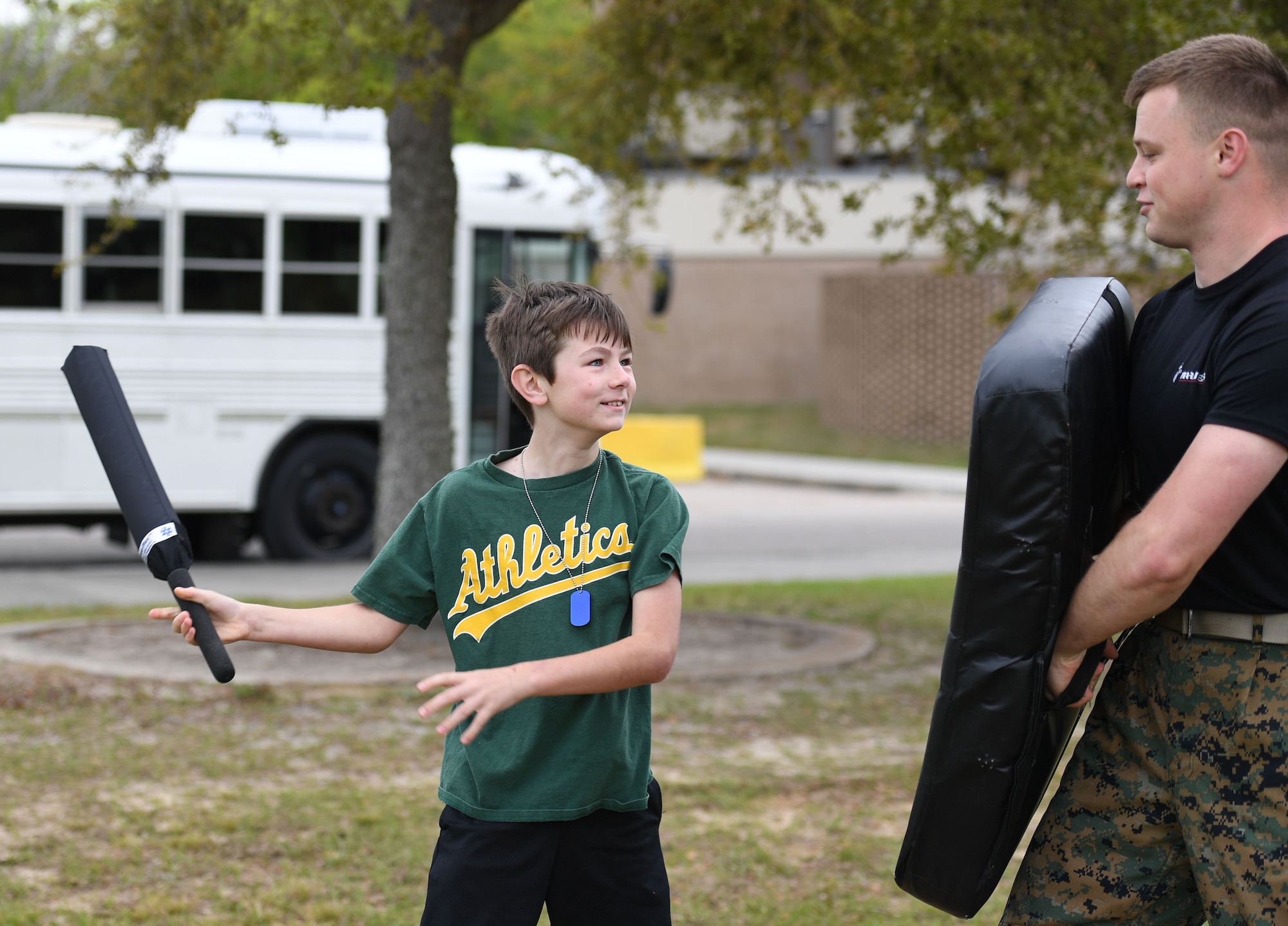 Logan Fish, son of Daniel Fish, 81st Civil Engineering Squadron fire fighter, and U.S. Marine Lance Corporal Dylan Matthews, Keesler Marine Detachment student, participate in an obstacle course during Operation Hero at Keesler Air Force Base, Mississippi, April 2, 2022. The event, hosted by the Airman and Family Readiness Center in recognition of the Month of the Military Child, gave military children a glimpse into the lives of deployed military members. Children received Operation Hero dog tags and t-shirts as they made their way through a mock deployment line as well as the opportunity to experience medical triage demonstrations, military working dog demonstrations and have their faces painted. (U.S. Air Force photo by Kemberly Groue)