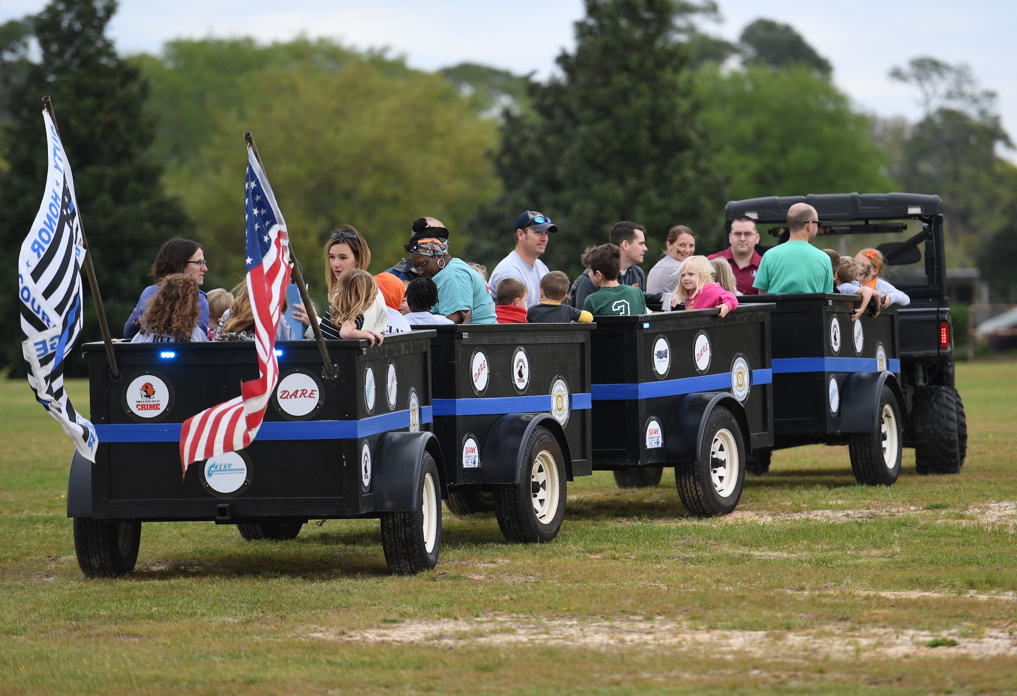 Keesler families ride a train through Heritage Field during Operation Hero at Keesler Air Force Base, Mississippi, April 2, 2022. The event, hosted by the Airman and Family Readiness Center in recognition of the Month of the Military Child, gave military children a glimpse into the lives of deployed military members. Children received Operation Hero dog tags and t-shirts as they made their way through a mock deployment line as well as the opportunity to experience medical triage demonstrations, military working dog demonstrations and have their faces painted. (U.S. Air Force photo by Kemberly Groue)