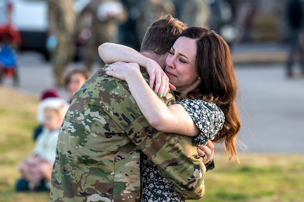 An airman hugs his wife.