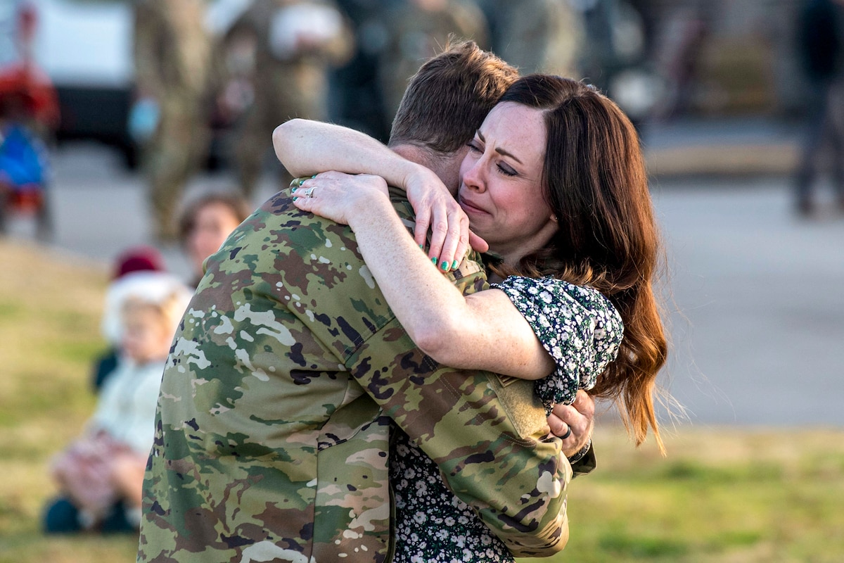 An airman hugs his wife.