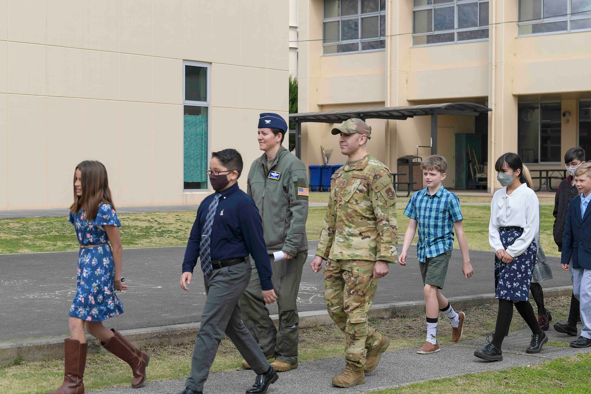 Joan K. Medal Elementary School National Honor Society (NEHS) students escort Col. Julie Gaulin, 374th Airlift Wing vice commander, and Chief Master Sgt. Kenneth Hauck, 374th Operations Group command chief, prior to a Month of the Military Child proclamation event at Yokota Air Base, Japan, April 7, 2022.
