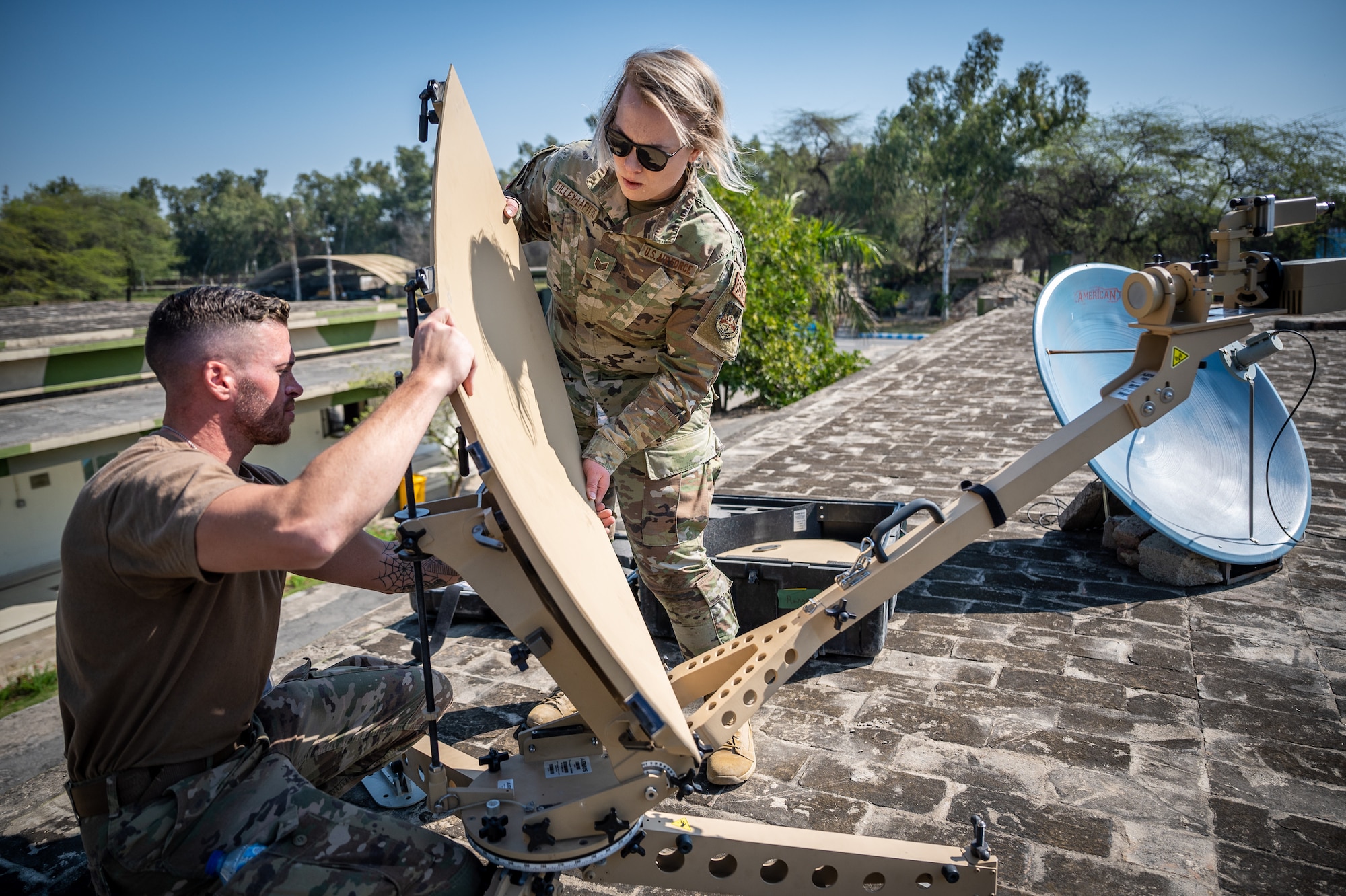 Staff Sgt. Benjamin Wilson, 332d Expeditionary Communications Squadron network infrastructure supervisor, and Staff Sgt. Morganne Tilley-Lafitte, 332d Expeditionary Contracting Office contingency contracting officer, set up an antenna system for a communications fly-away kit at a Pakistan operational air force base, Feb. 27, 2022. The kit allowed U.S. Air Force members from across the Air Forces Central area of responsibility to manage communications while supporting Falcon Talon 2022, an Agile Combat Employment operation and the first bilateral training event between the United States and Pakistan since 2019. (U.S. Air Force photo by Master Sgt. Christopher Parr)