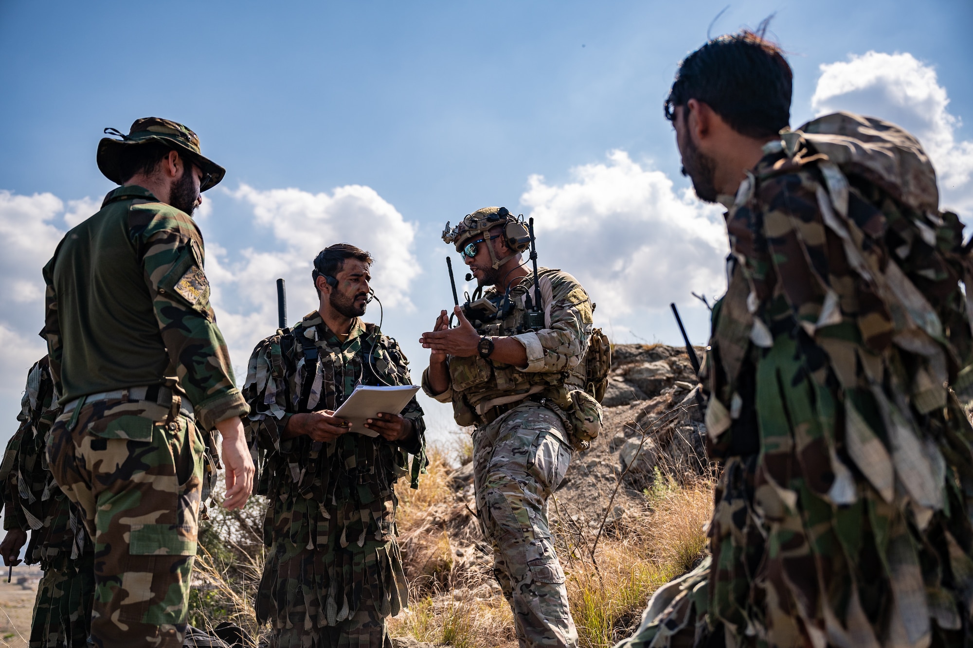 Tech. Sgt. Brandon Tatum, Air Warfare Center chief of joint terminal attack control training, works with Pakistan commandos to locate and coordinate various targets of opportunity during a training scenario at a Pakistan military range, March 1, 2022. The partner nation training conducted was part of Falcon Talon 2022, an Agile Combat Employment operation and the first bilateral training event between the U.S. and Pakistan since 2019. (U.S. Air Force photo by Master Sgt. Christopher Parr)