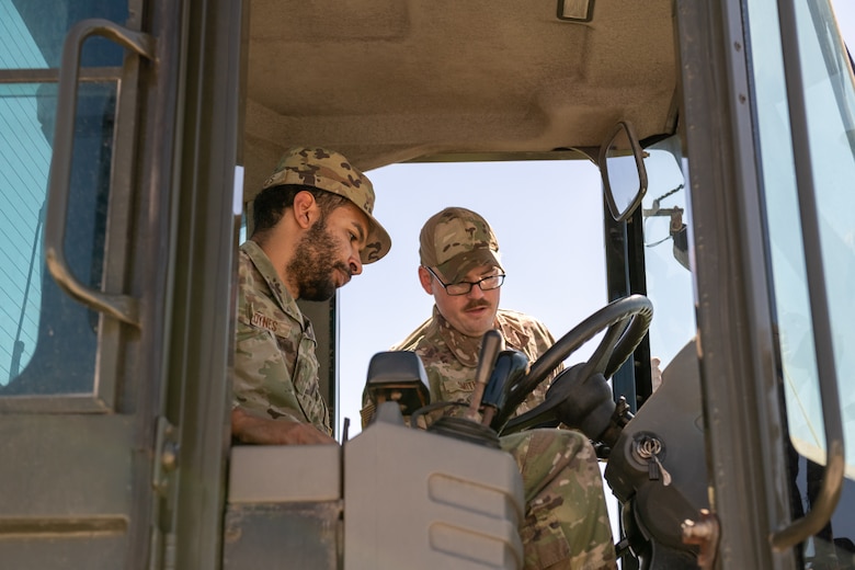 U.S. Air Force Staff Sgt. Darrin Smith, 45th Civil Engineer Squadron, center, instructs Staff Sgt. Tevin Loyne, 45th CES, left, on the proper operation of a loader during a training session March 17, 2022, at Patrick Space Force Base, Fla. Smith and Loyne are preparing for Readiness Challenge VIII, a CE competition that tests Airmen on their abilities to perform tasks associated with their career field. (U.S. Space Force photo by Josh Conti)