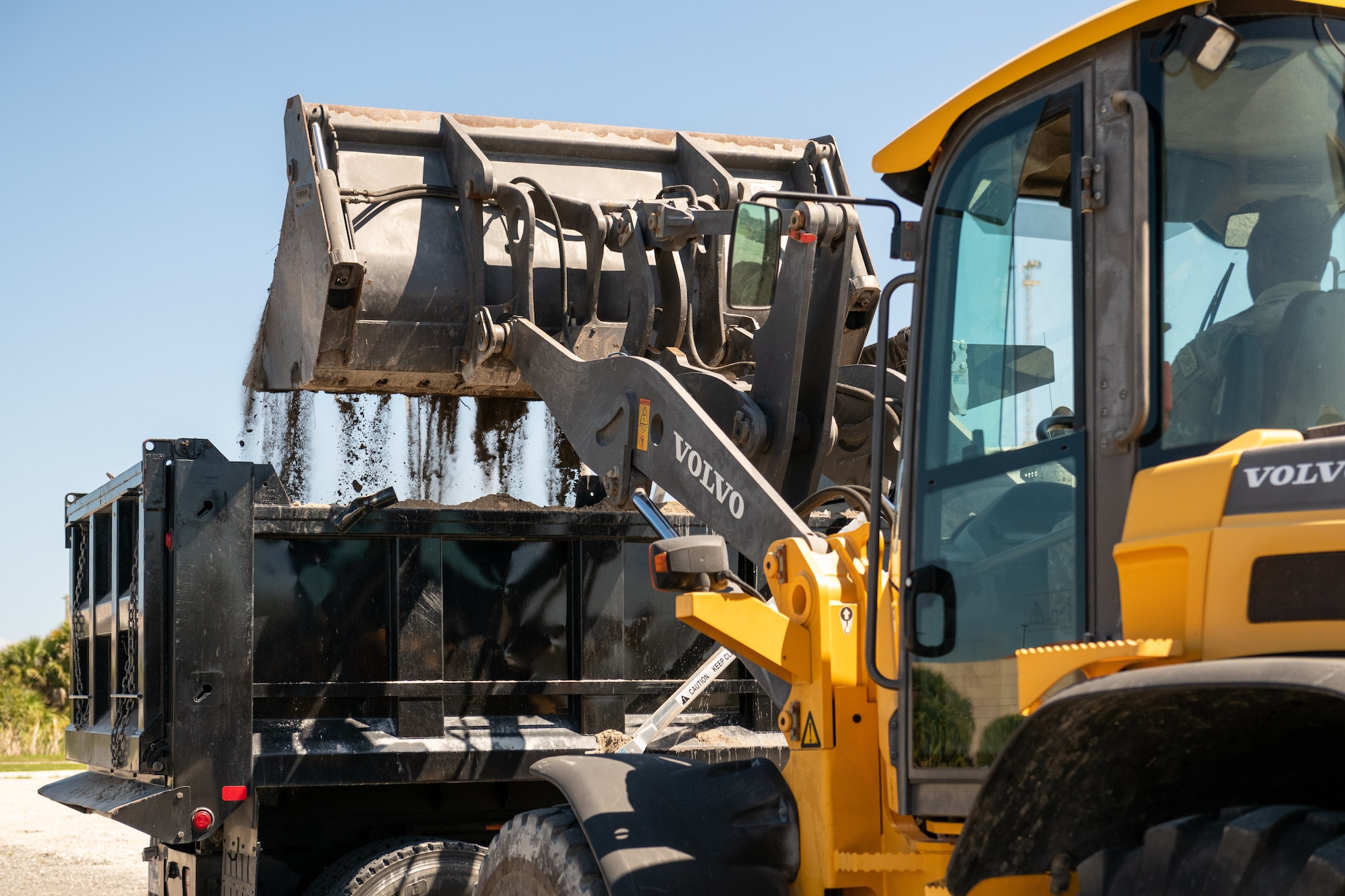 A member of the 45th Civil Engineer Squadron empties soil into the back of a truck March 17, 2022, at Patrick Space Force Base, Fla. Nearly 30 CE Airmen from PSFB are preparing to compete in Readiness Challenge VIII, a competition that tests CE Airmen on their abilities to perform tasks associated with their career field. (U.S. Space Force photo by Josh Conti)