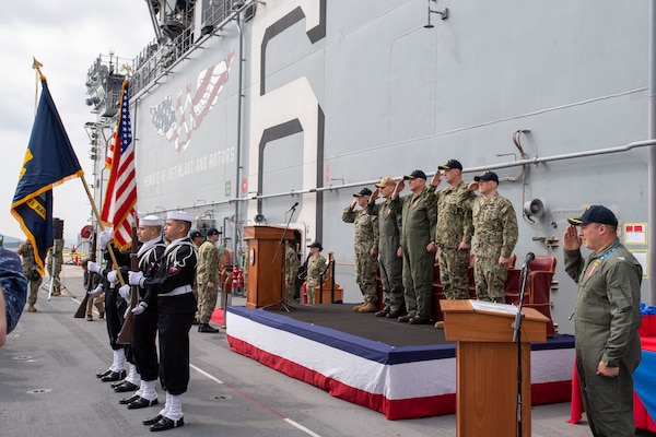 SASEBO, Japan (April 7, 2022) Sailors assigned to the forward-deployed amphibious assault ship USS America (LHA 6) present the colors during the National Anthem at a change-of-command ceremony on the ship’s flight deck. America, lead ship of the America Amphibious Ready Group, is operating in the U.S. 7th Fleet area of responsibility to enhance interoperability with allies and partners, and serve as a ready response force to defend peace and stability in the Indo-Pacific region. (U.S. Navy photo by Mass Communication Specialist 2nd Class Walter Estrada)